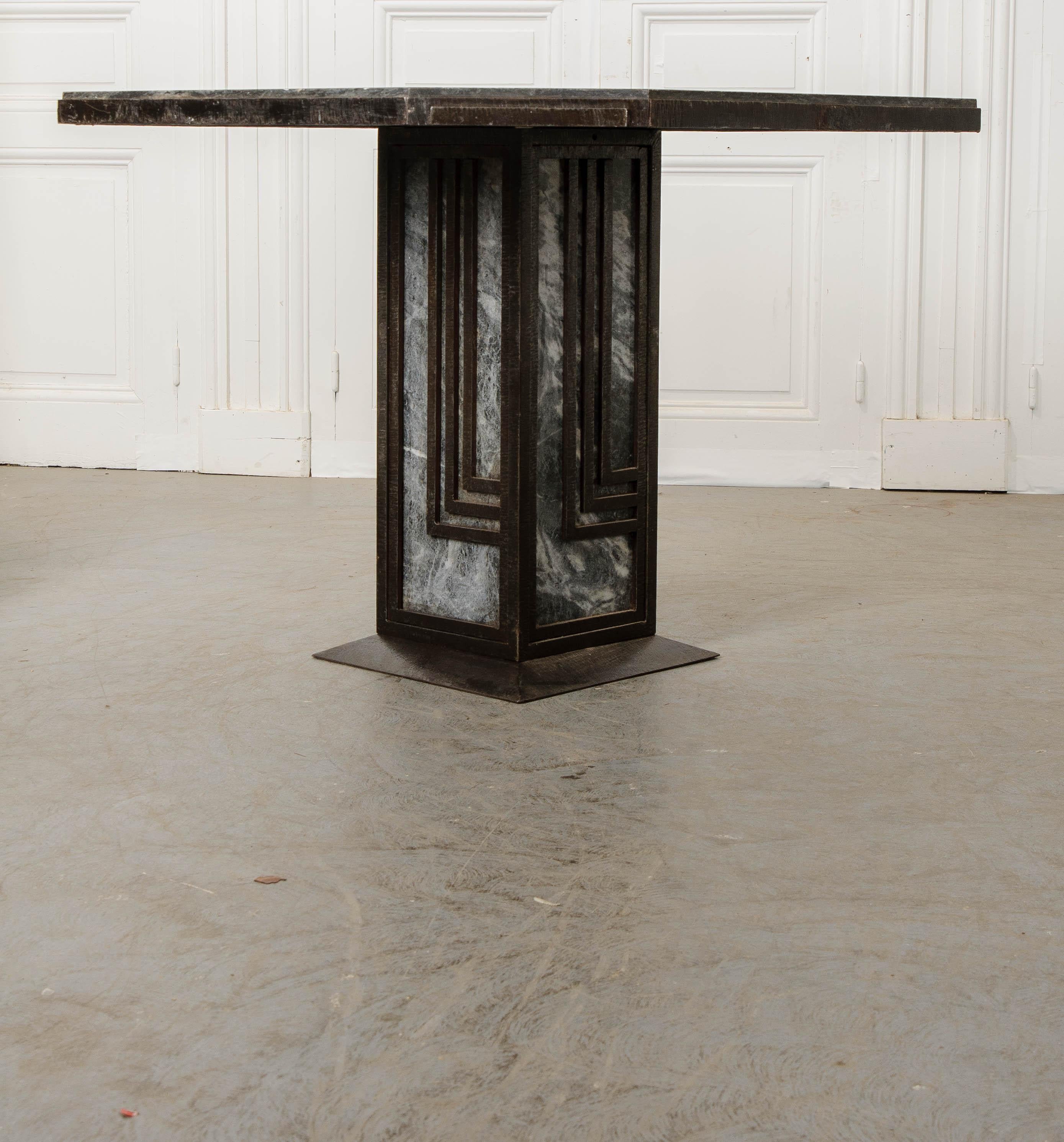 An octagonal shape provides this stylish French Art Deco dining table with a fabulous geometric silhouette. The table has a frame made of black painted iron that holds all of the heavy marble where it needs to be. The Sainte-Anne marble is gray in