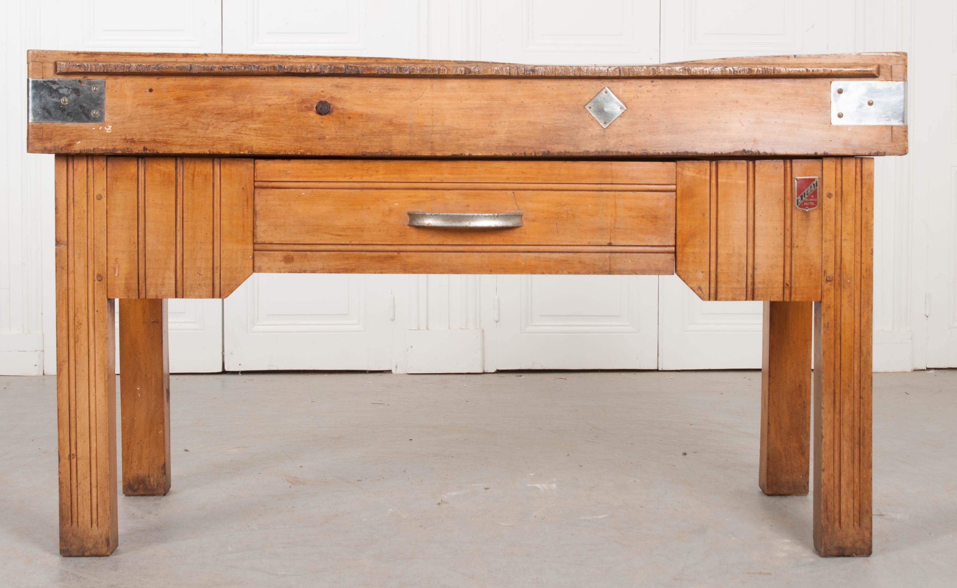 Une belle table de boucher, fabriquée à Nantes, France, vers 1920. Le plateau de la table présente une patine exceptionnelle. Une rainure a été laissée par des décennies de travail au couteau et de boucherie. Le dessus est relié par des attaches en