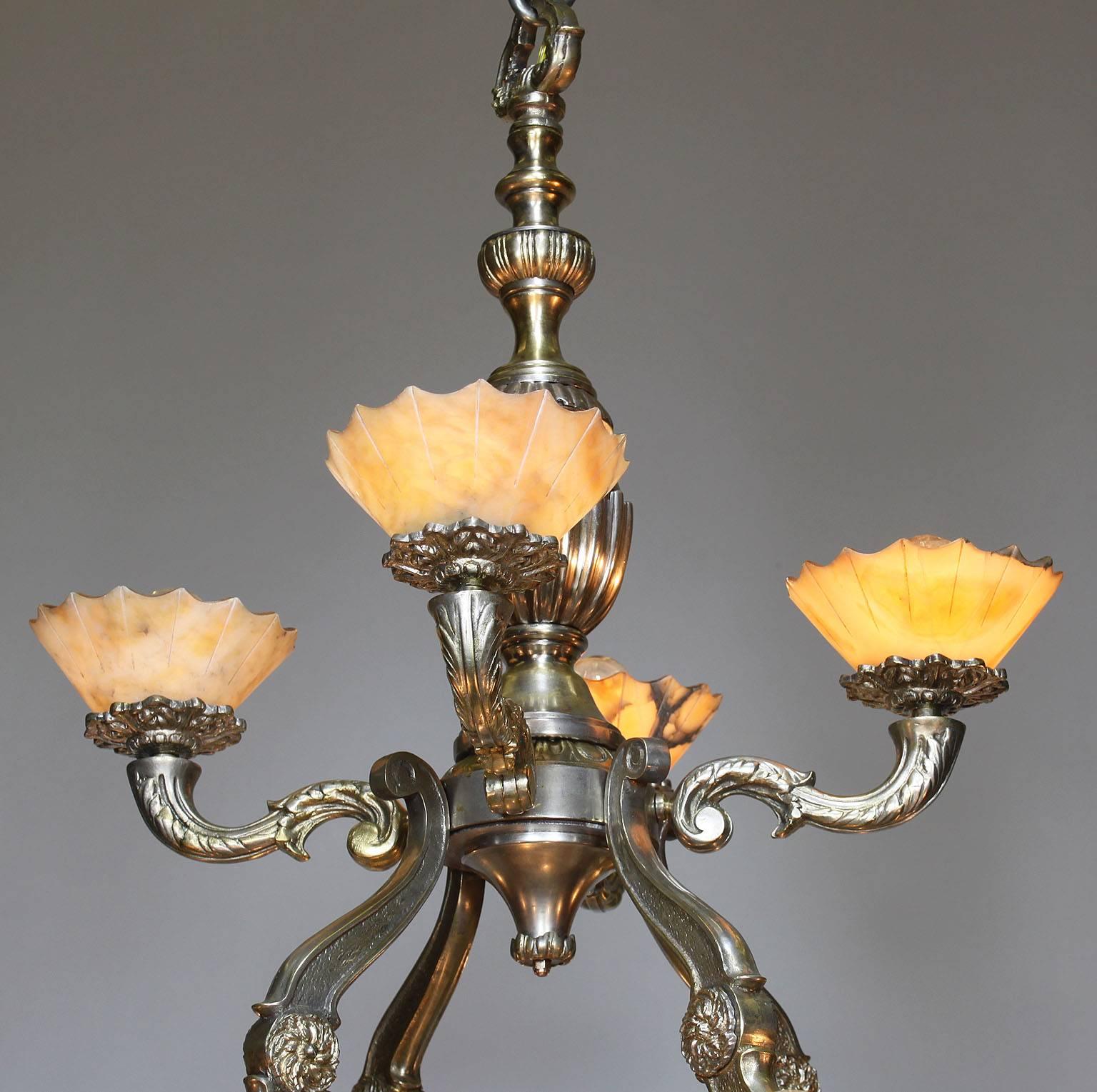 A French early 20th century Art Deco silvered bronze and carved veined Alabaster two-tier fourteen-light chandelier. The silver plated bronze frame with four upper tier scrolled lights and four pairs of scrolled lower tier lights, all surmounted