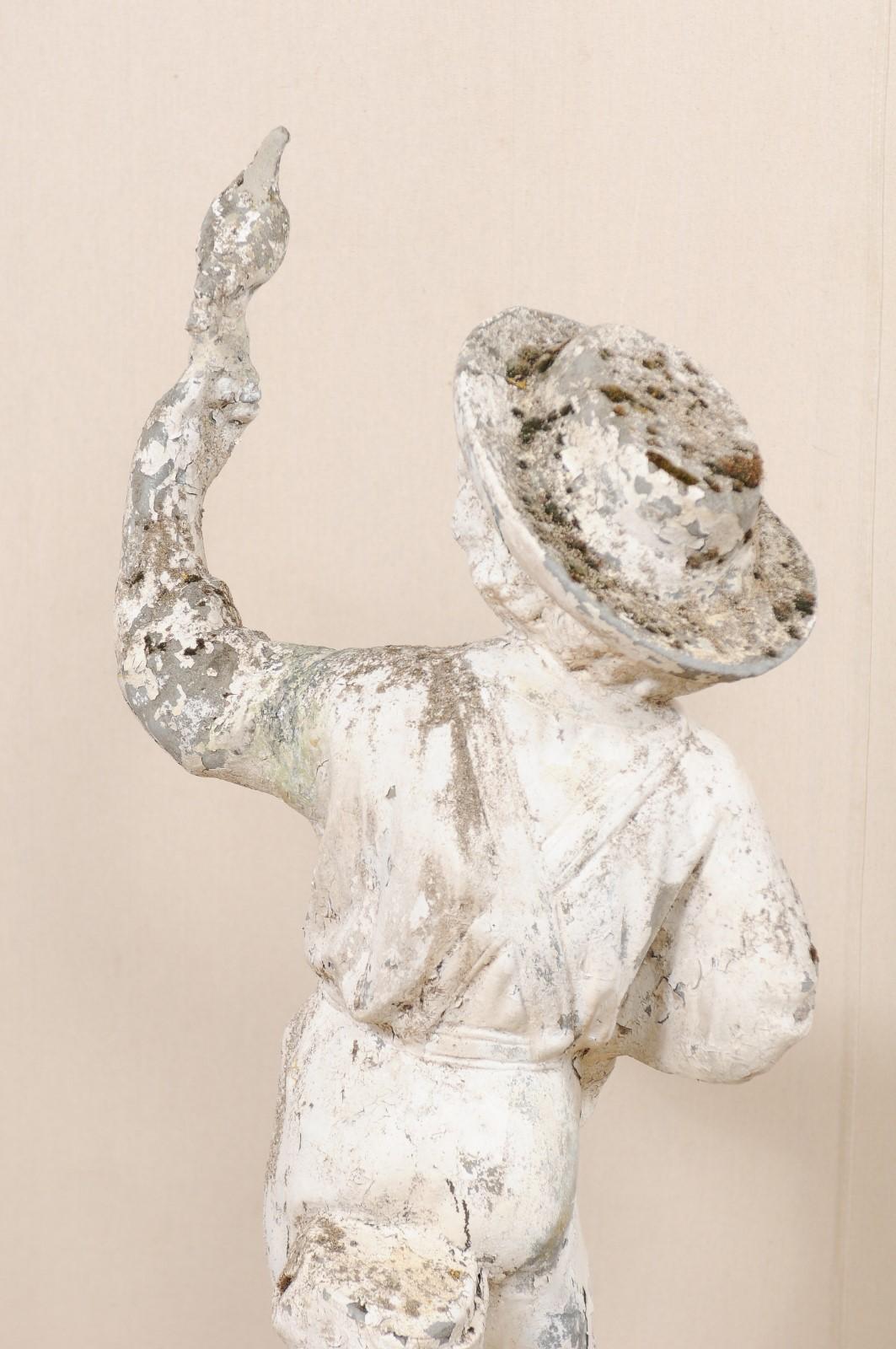 Pierre artificielle Sculpture de jardin ancienne en pierre moulée représentant un garçon avec un oiseau, d'une hauteur de plus de 2 mètres. en vente