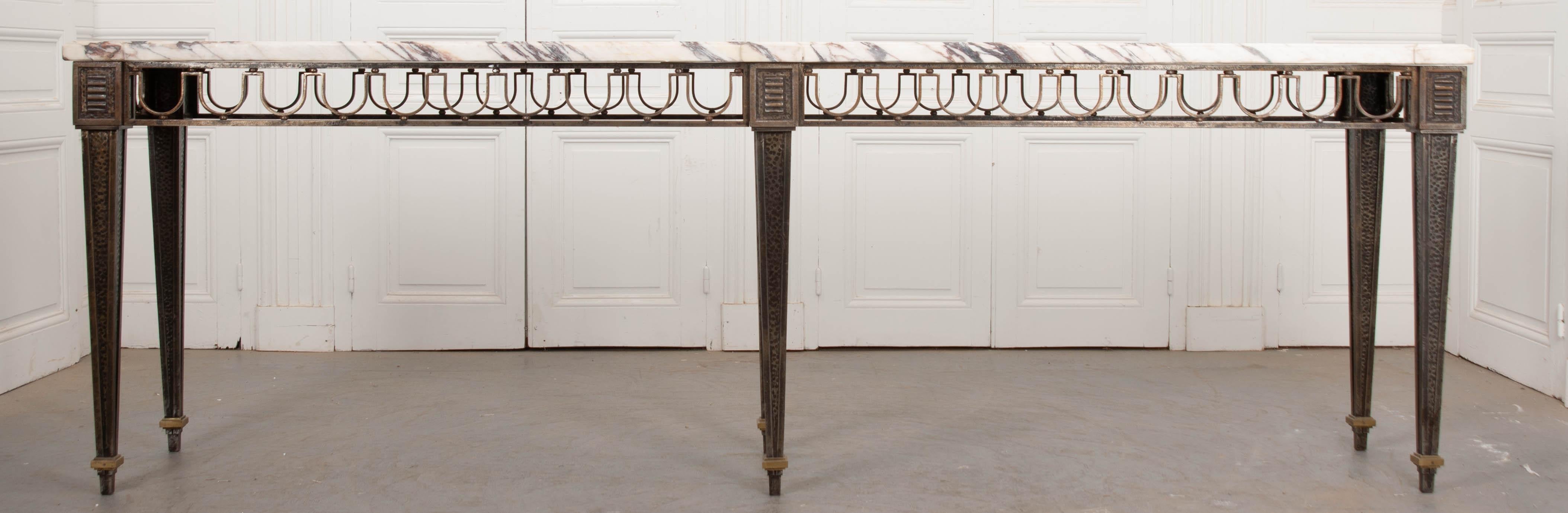 A fantastic wrought iron and marble console table, made in France, circa 1930. Gilbert Poillerat was a prolific French artist, known for his ironwork. Though he started with jewelry, he quickly took to creating furniture, employing techniques that