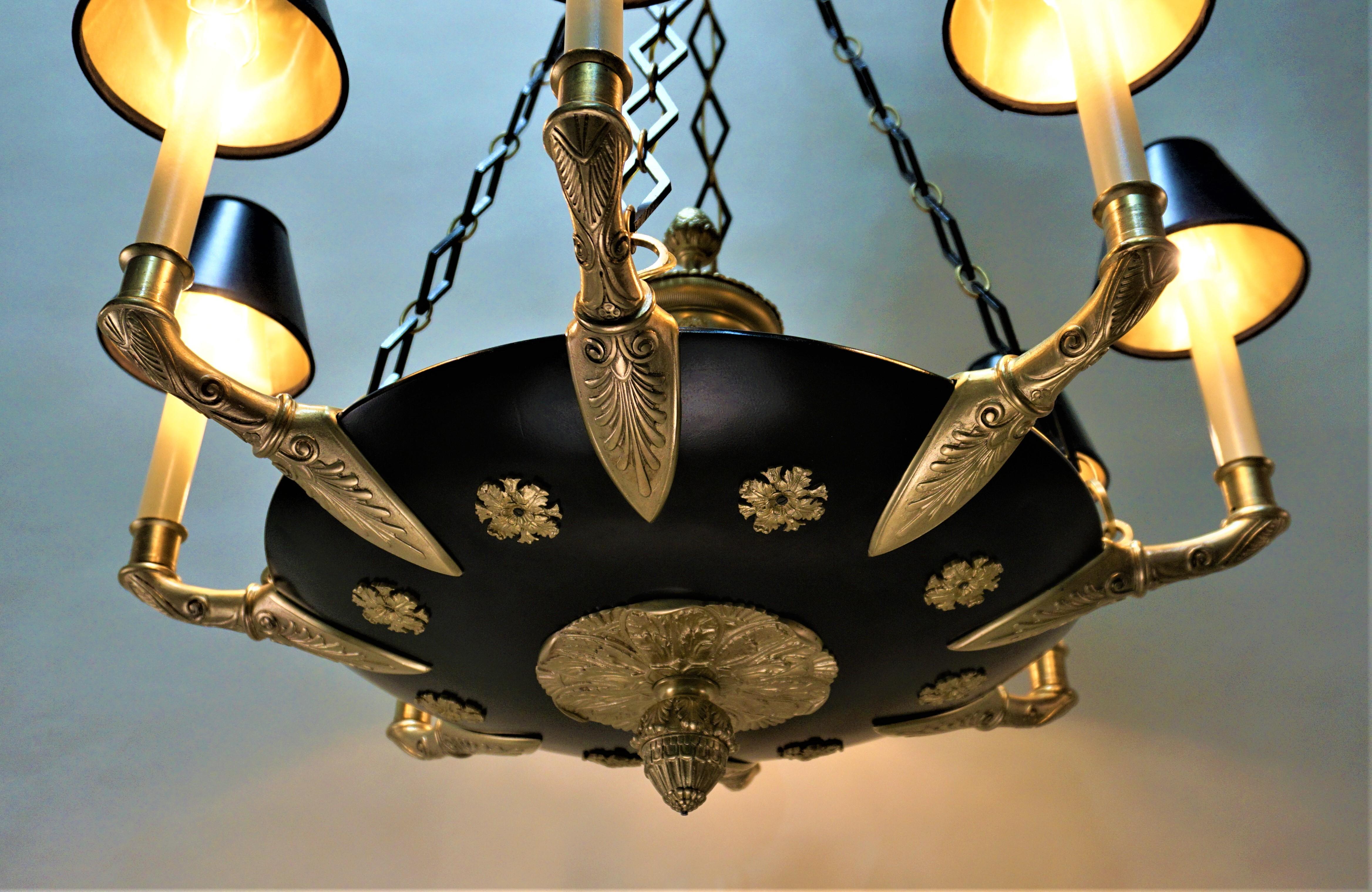 Antique French Empire neoclassical design bronze eight-light chandelier.