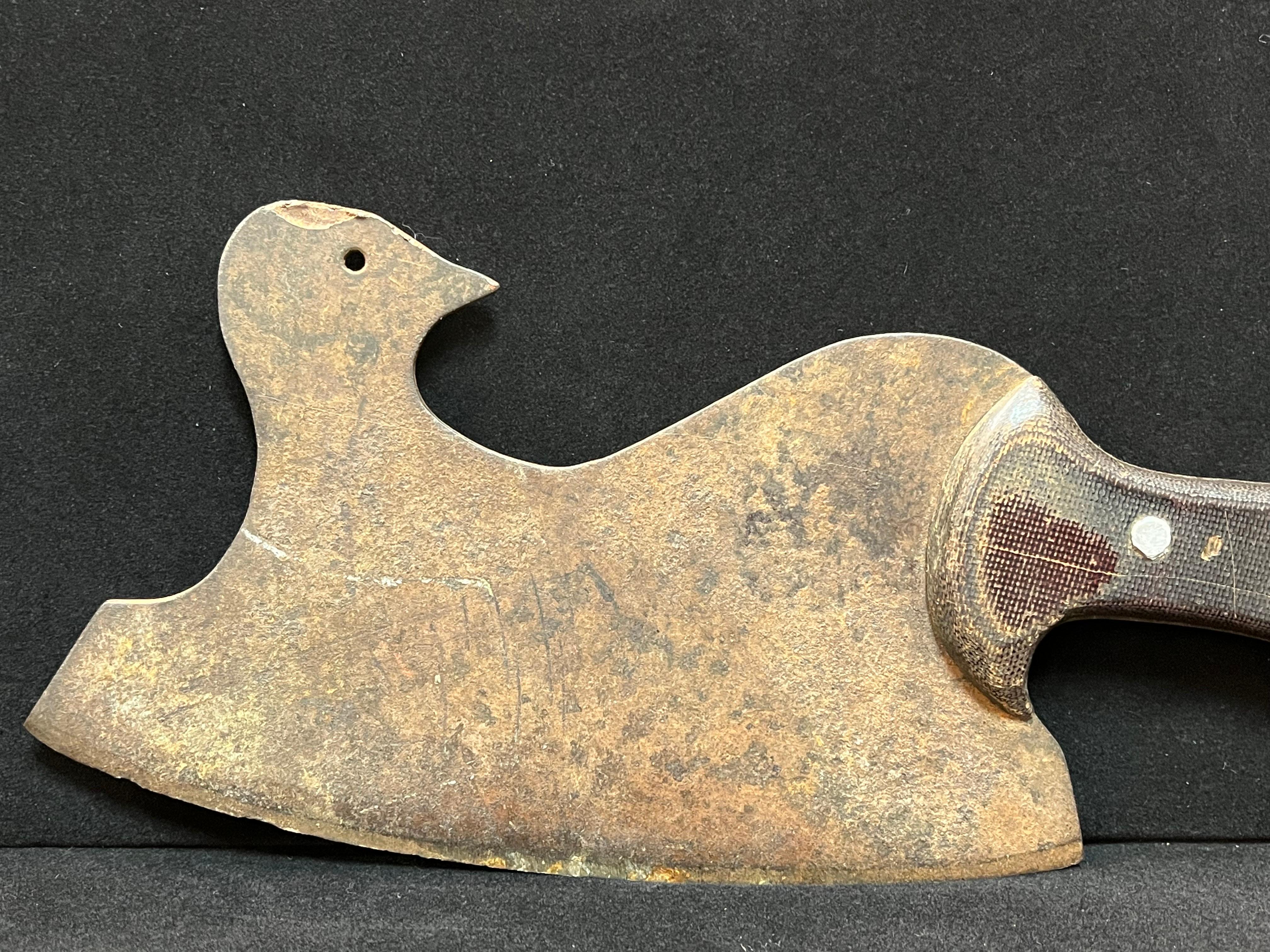 An early 20th century French figural butcher's cleaver in the form of a bird. The bird looks back over its shoulder at the chef holding the handle of the cleaver. Perhaps considering what may happen next. The metal blade is formed and shaped,
