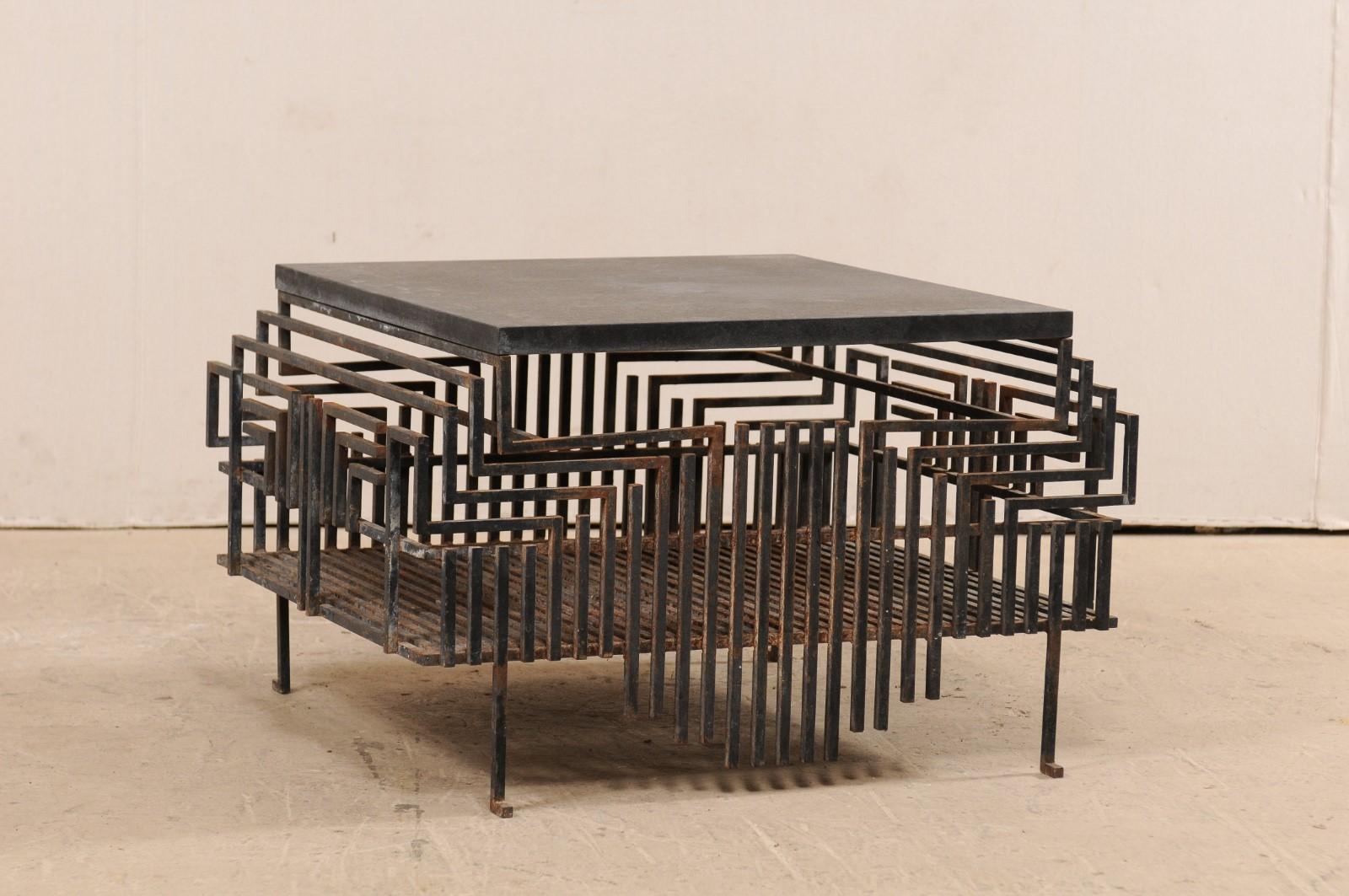 This is a one of a kind coffee table, which has been fashioned from a large-scale French iron fireplace grate (from the early to mid 20th century) and topped with a newer honed granite top. This unique table features a honed granite top which rests