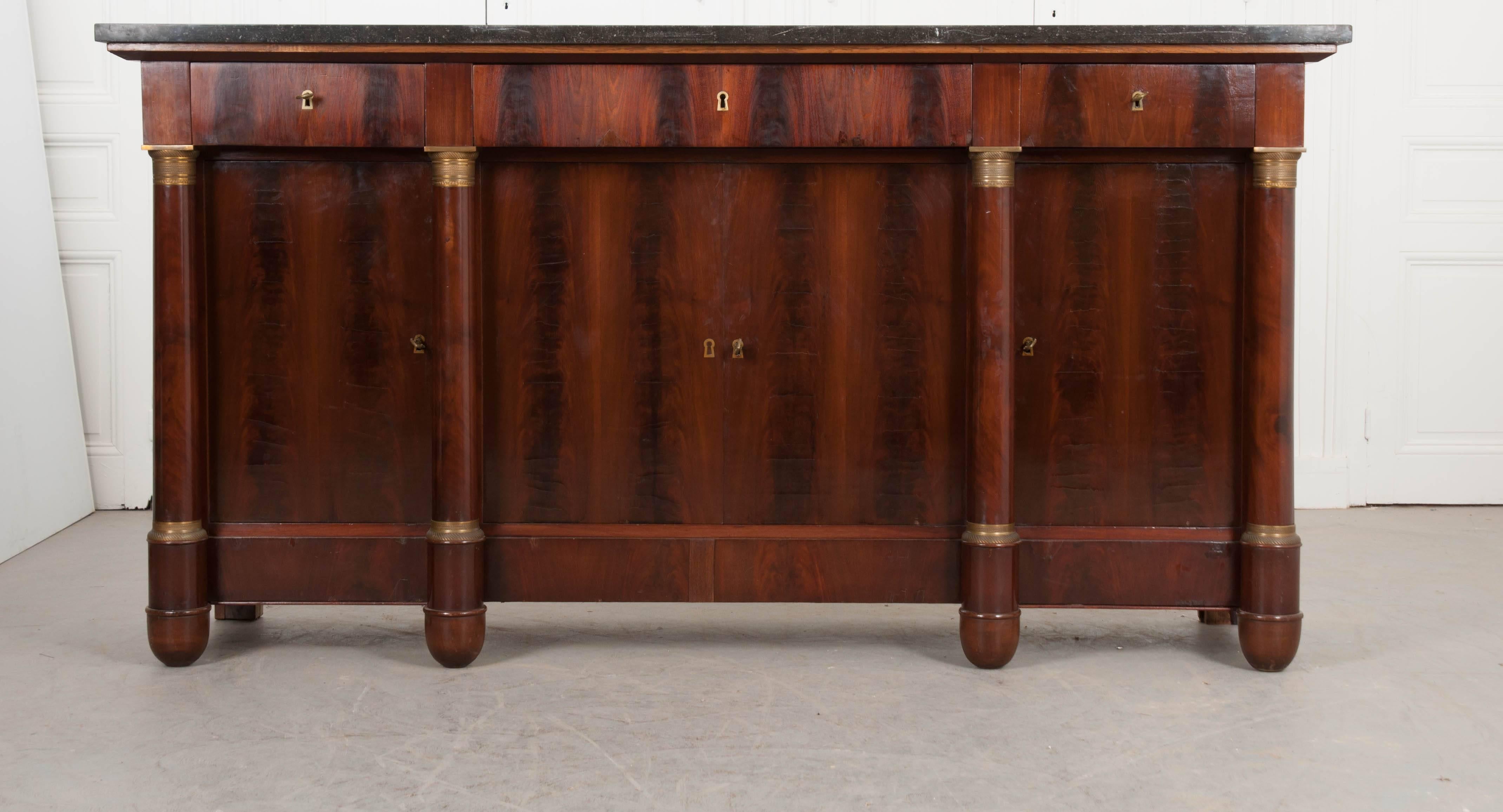 An extraordinary Empire style enfilade with black fossil marble top, made in France towards the beginning of the 20th century. The beautiful top is in wonderful antique condition, with abundant tiny fossils present. The apron contains three drawers,