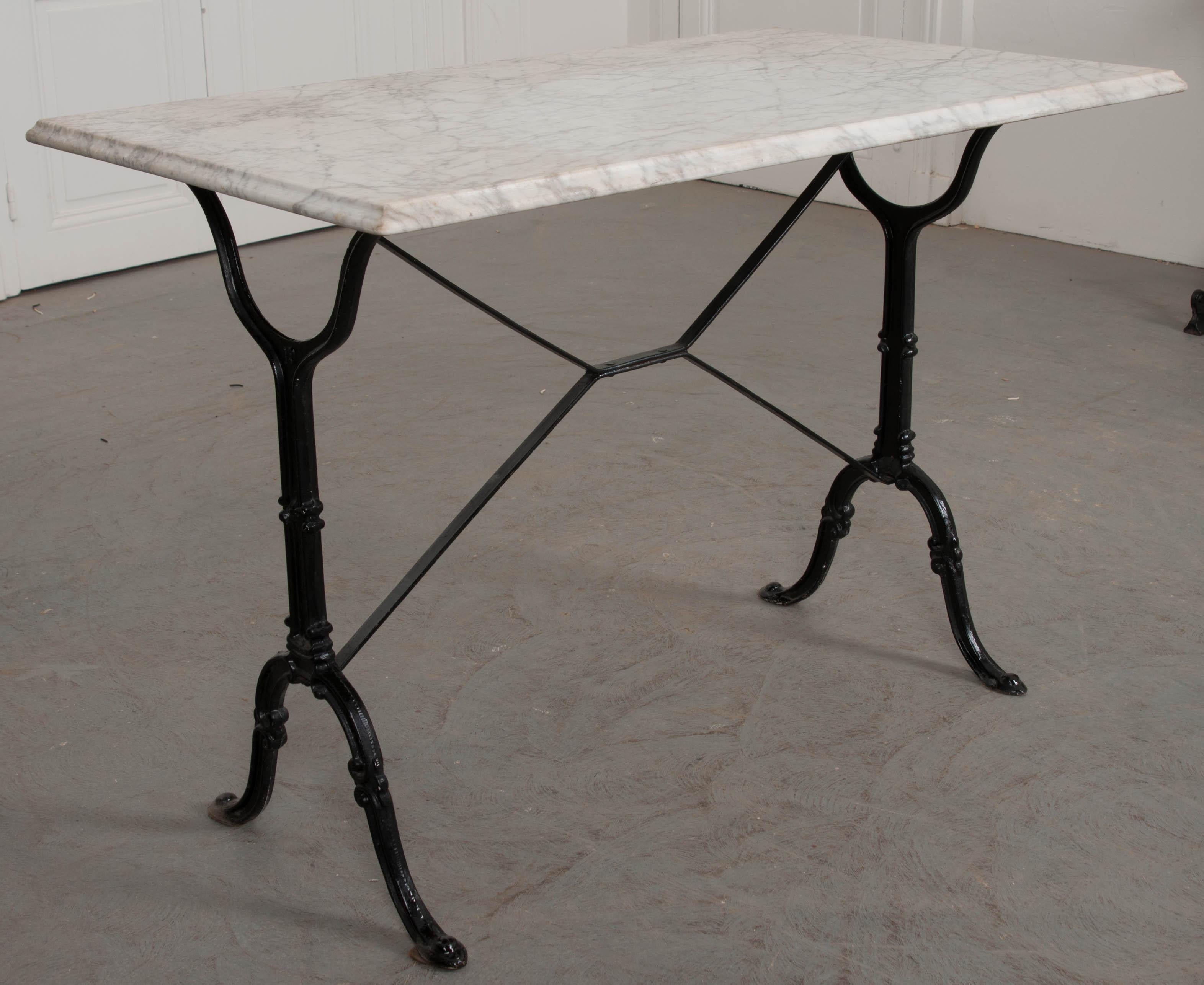 This amazing French marble top garden table was made at the beginning of the 20th century. The white marble top is in antique condition, with grey veins and an ogee finished edge. The iron base is classically styled, with fashioned upright supports,
