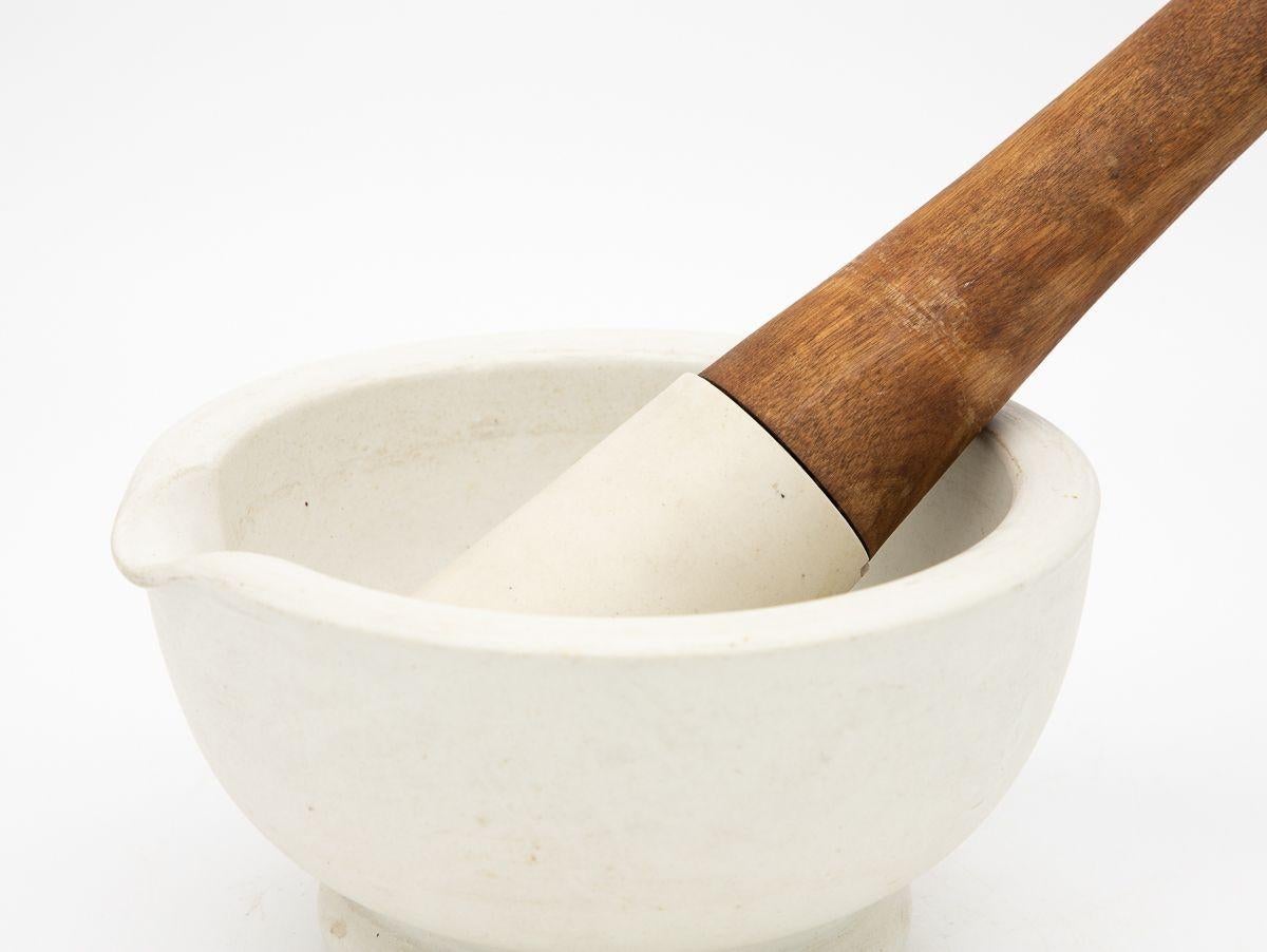 An early 20th century French white marble and pestle. The pestle has a wood handle and a stone base. Pestle measures 12