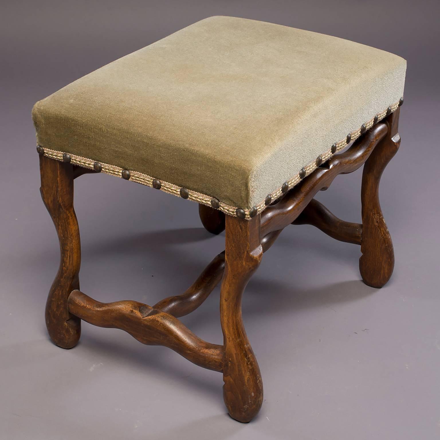 Classic Os de Mouton stool with dark wood frame, sage green velvet upholstery and brass nail head trim, circa 1920s. Curvy support stretchers at base and top front and back. Versatile size can be used as a stand alone stool or small bench, or pair