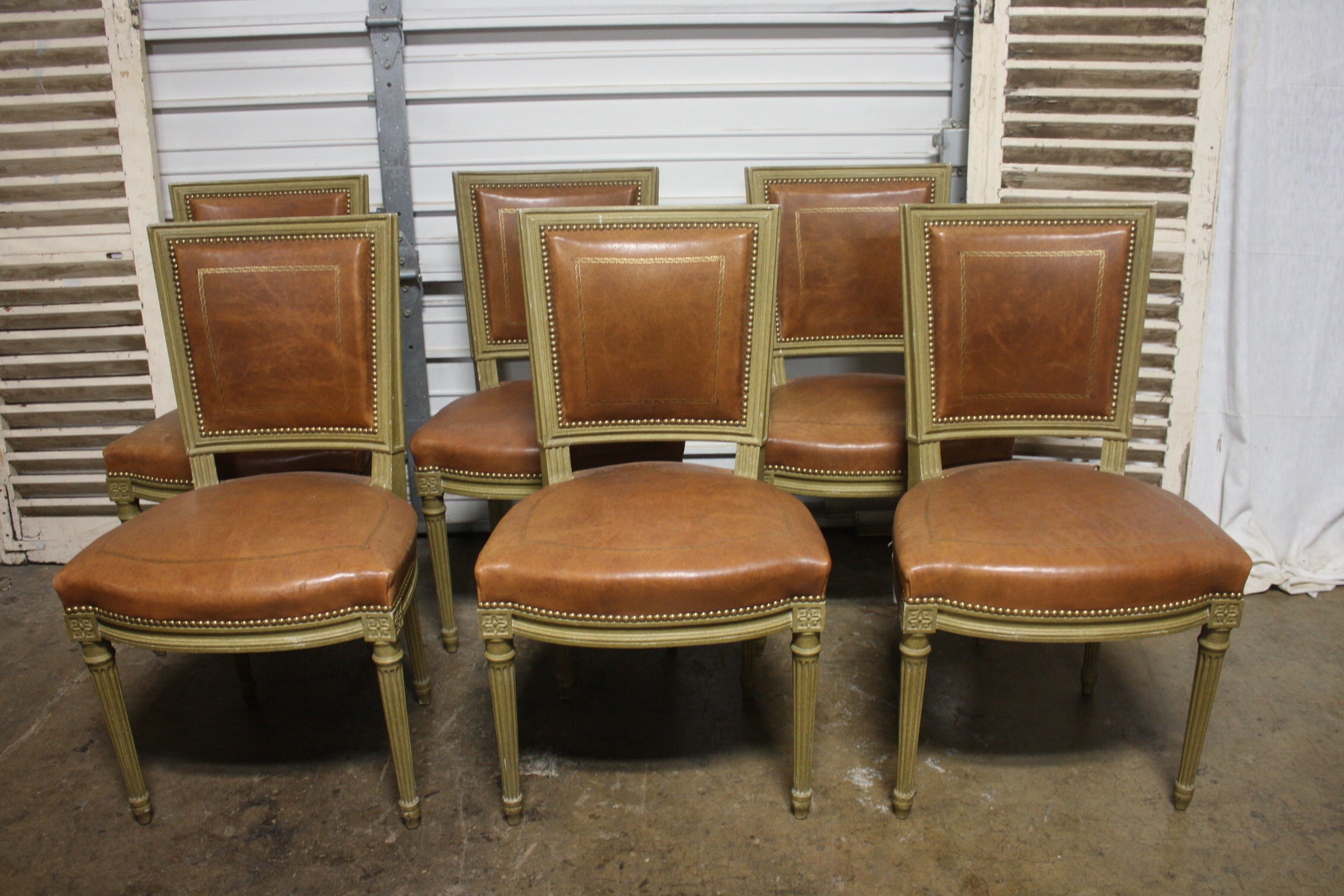 Beautiful set of 6 dining room chairs signed Gouffe a Paris. The chairs are covered of leather and painted. Very Chic and so much quality.