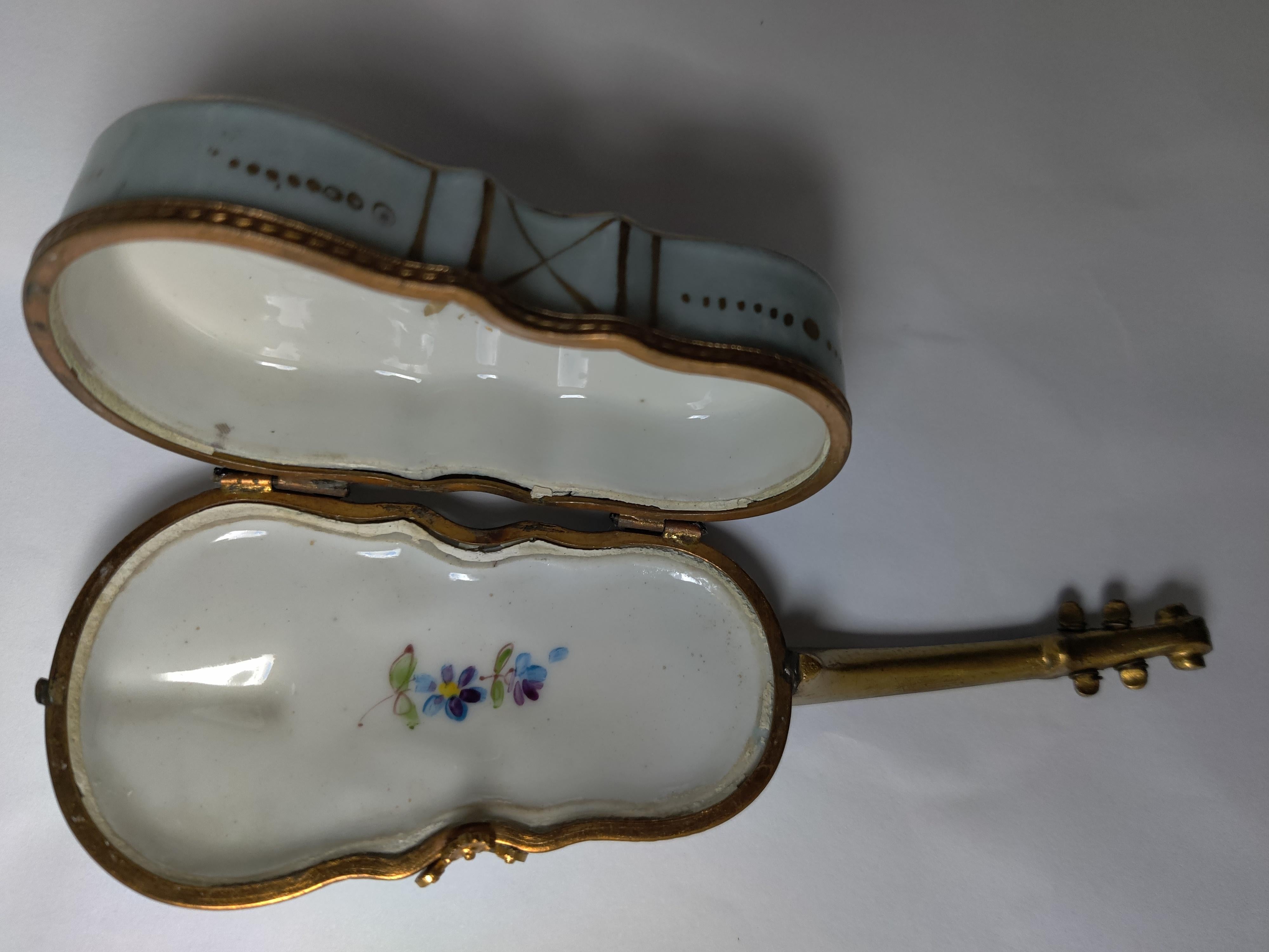 French Early 20th Century Violin Shape Pill/Trinket Box
Painted Flowers on outside - front and back
Brass trim, wire for strings.
Neck is brass.