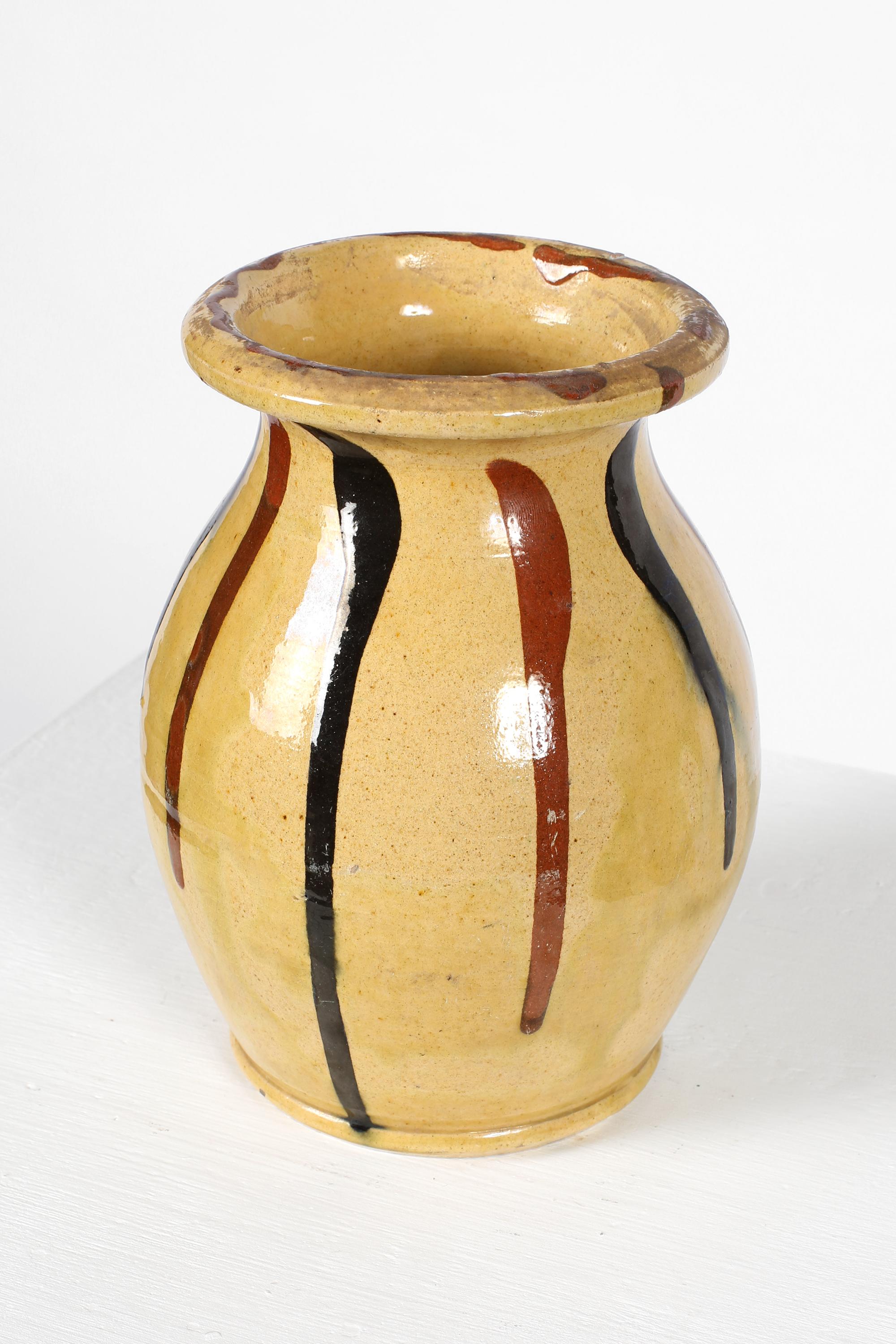 Vase en céramique émaillée jaune pâle de Vallauris à décor de bandes noires et feu alternées. Français, c.C. 1900.