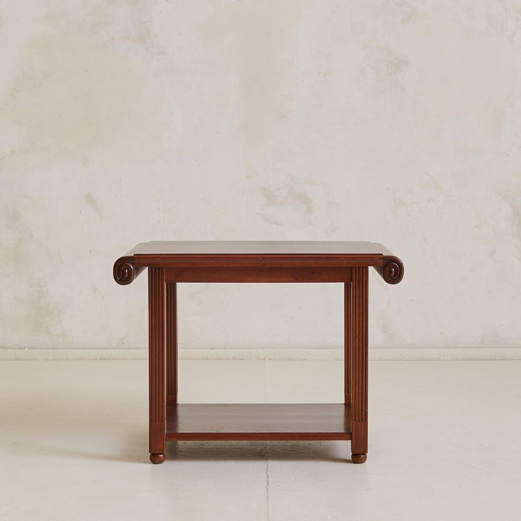 A French side table in richly grained Eastern Rosewood, sourced in the South of France. Dating to the 1940s, the piece balances architectural form with stylized details—fluted column legs capped in rounded feet and topped with a waterfall-edge