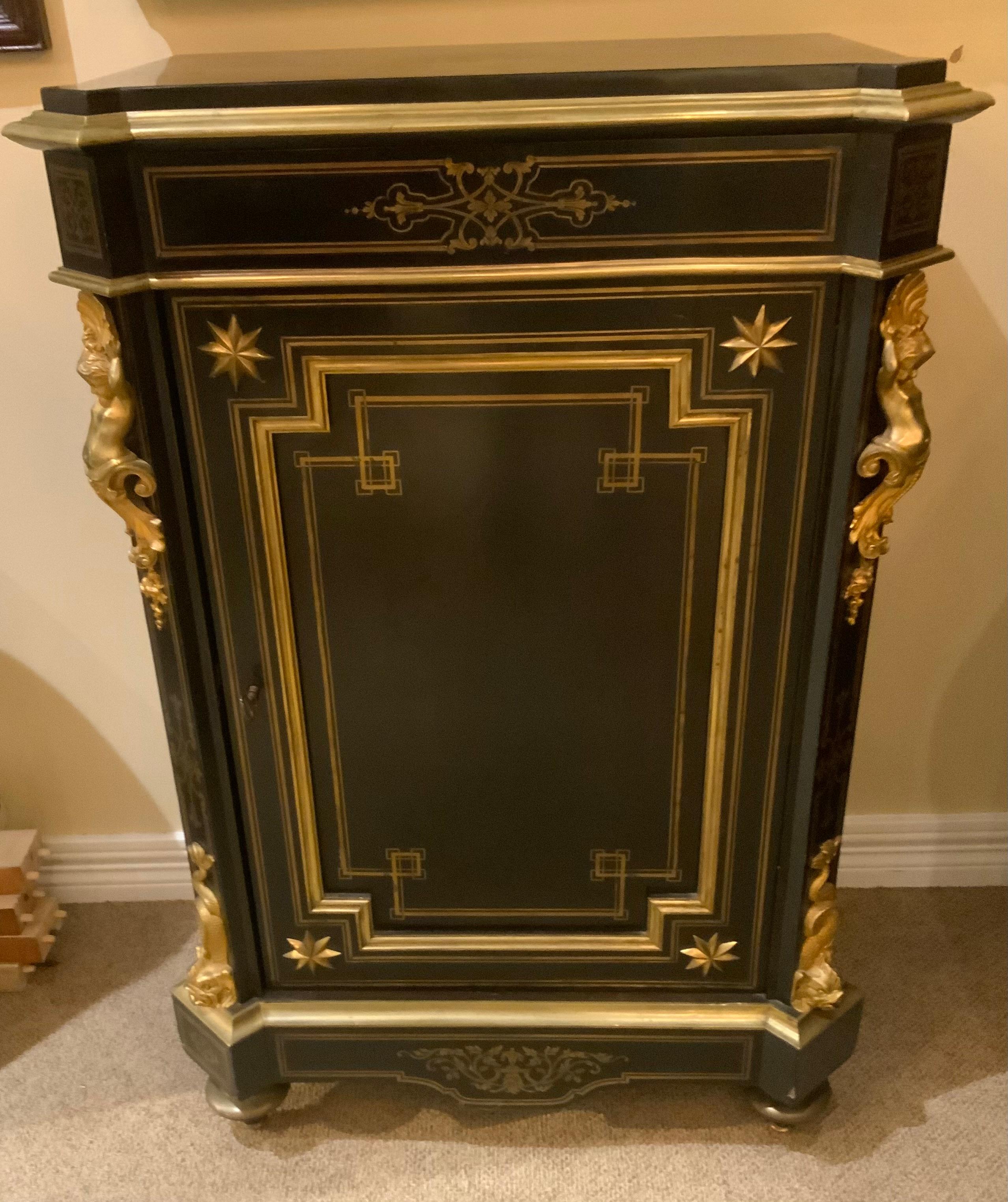 The ebonized wood contrasting the gilt bronze mounts
Makes this a highly desirable piece. It stands on
Toupie feet. The top is black marble that is surrounded by
By bronze mouldings. It has a lock with key that opens
To two shelves for storage