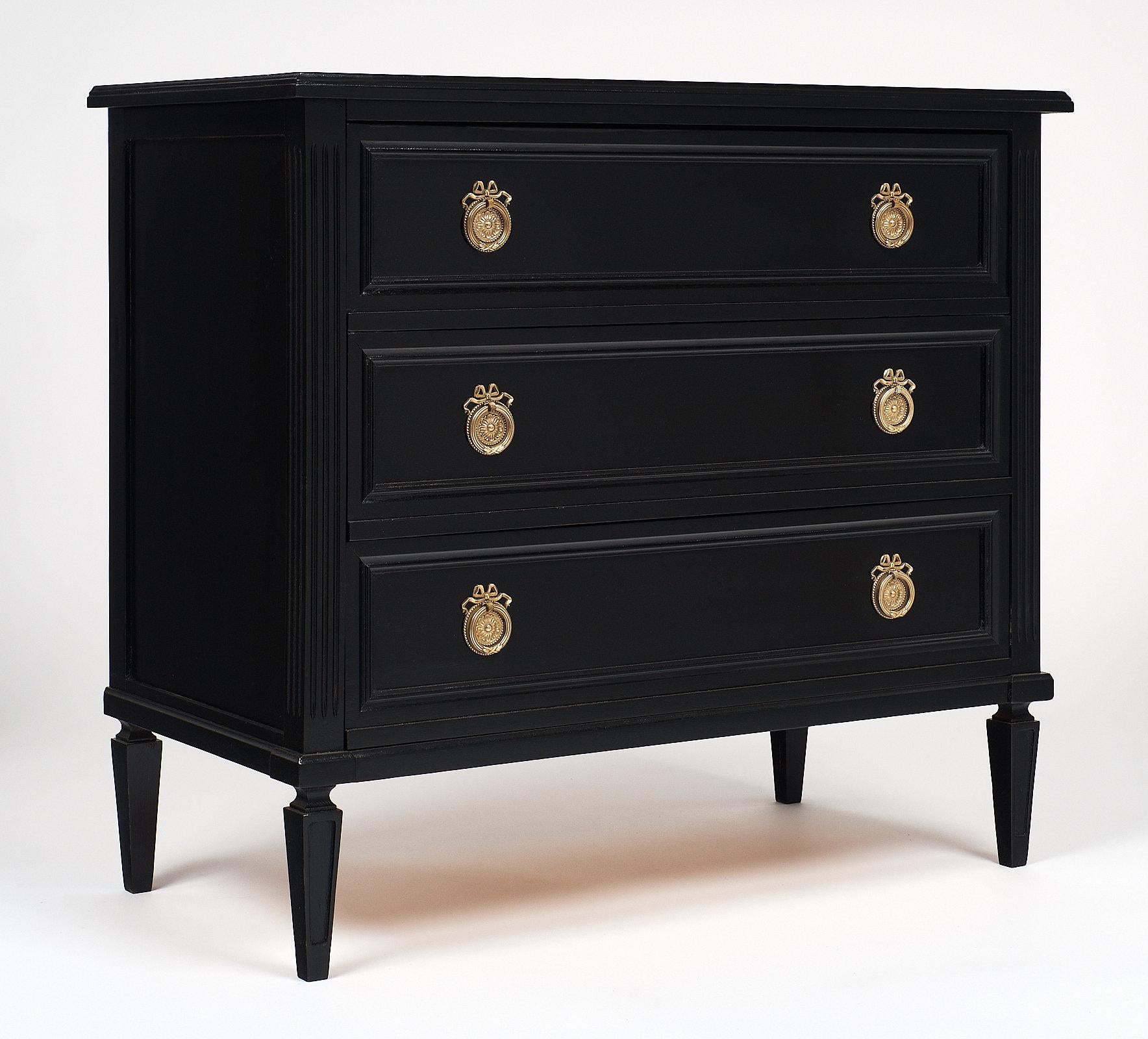 Directoire style French ebonized chest made of solid mahogany and featuring gilt brass hardware. We loved the perfect proportions of this lovely piece, with three dovetailed drawers and tapered legs. It has been finished with a French polish for a