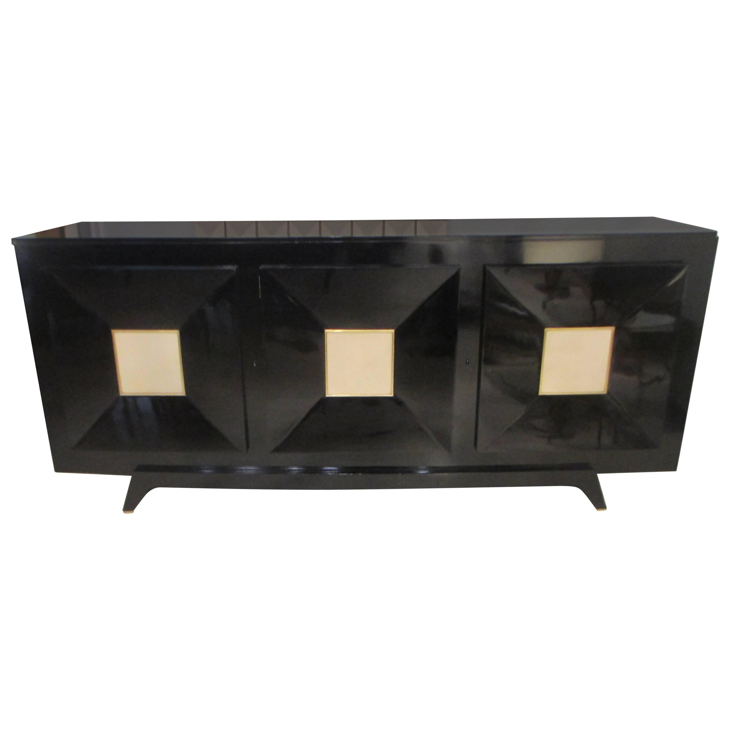 French ebonized midcentury sideboard featuring three central drawers inset with parchment. The interior features three individual shelves.