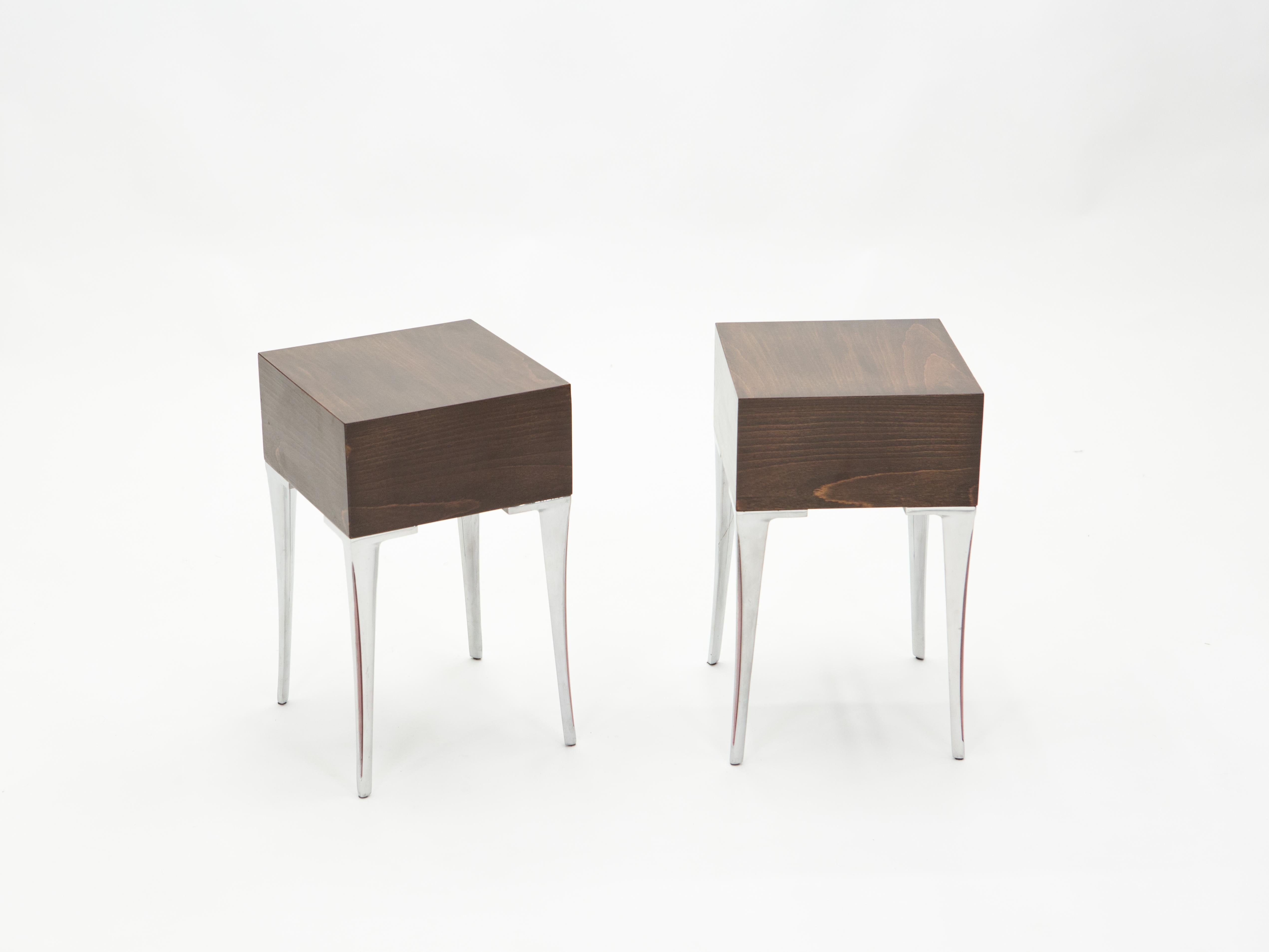 This pair of lined and elegant end tables or bedside tables is made from ebony veneer wood, with beautiful steel feet, in the early 1970s. Vintage and sophisticated, typically 1970s vibe, they feature a boxy square top with sinuous saber legs with