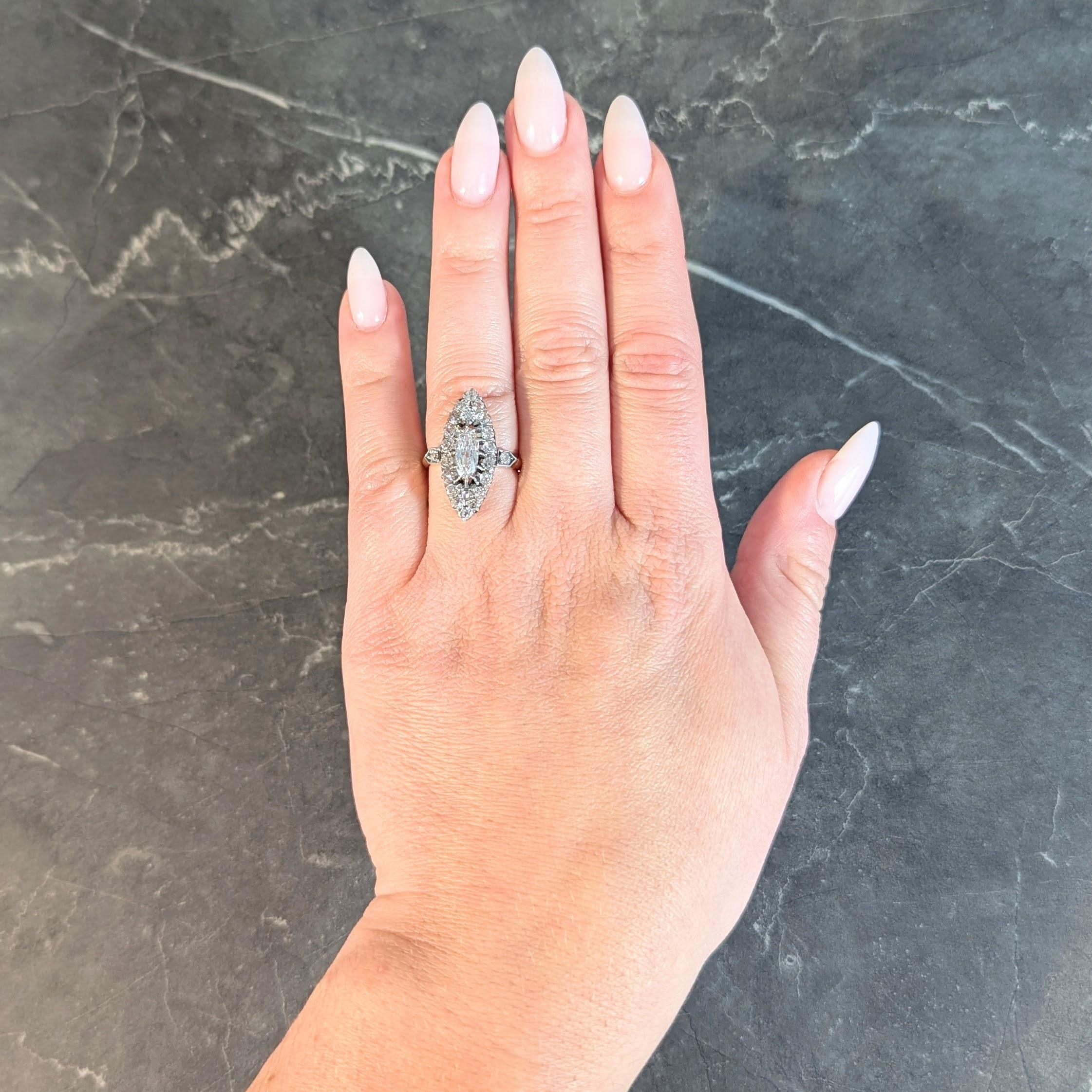 Centering an elongated oval cut diamond weighing 0.66 carat - H color with VS1 clarity
Set with platinum talon prongs floating above a navette shaped halo surround
Prong and bead set throughout with old mine and old single cut diamonds
Flanked by