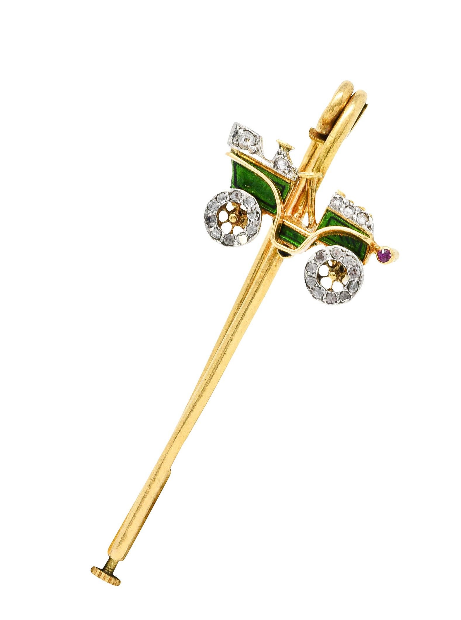 Gold safety pin features a depiction of an antique car

Glossed in bright green enamel with articulated spinning wheels

Accented throughout by rose cut diamonds and has one ruby as a headlight

Completed by a pin stem with plunging clasp

With