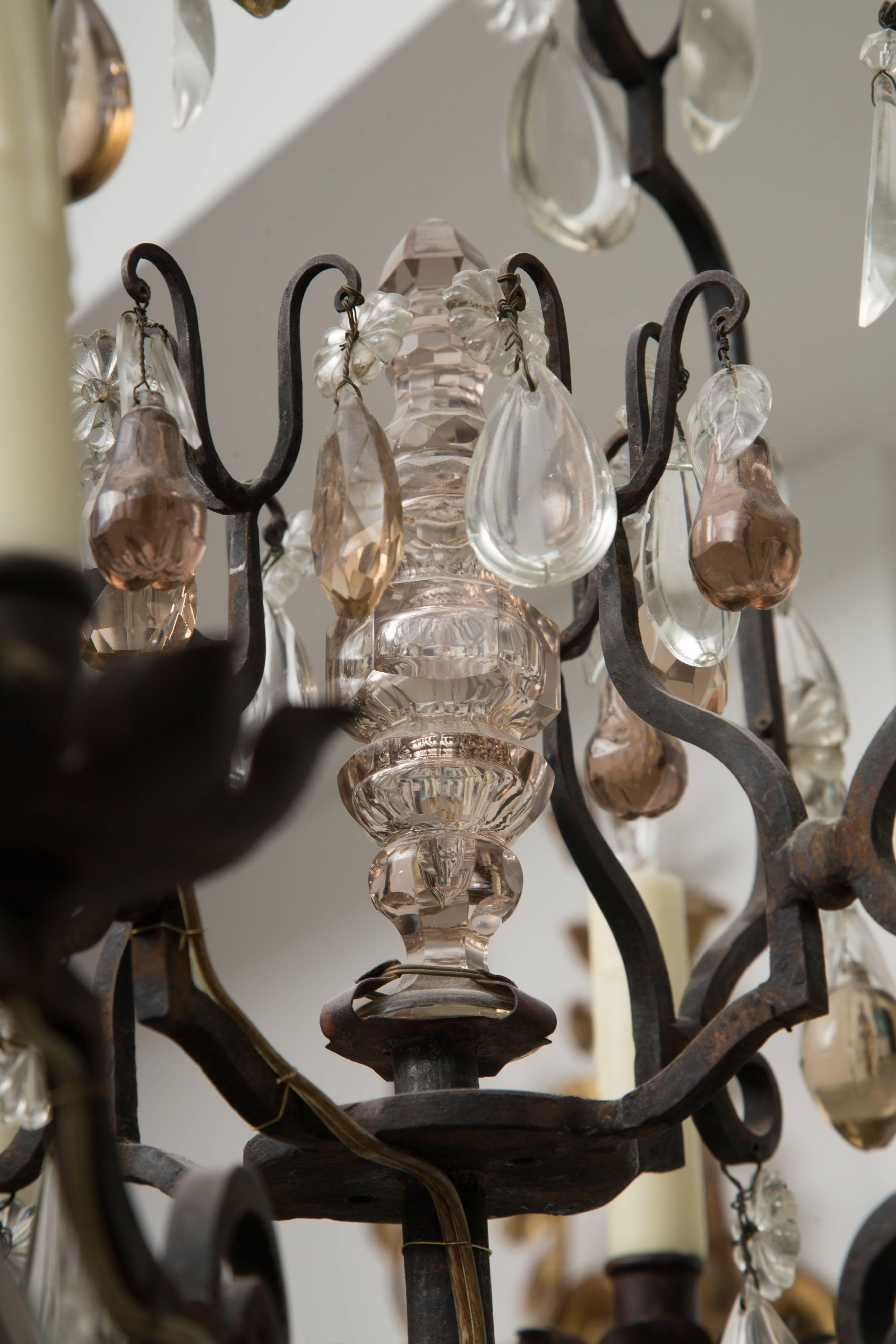 This is a romantic lantern-form French bronze eight-light chandelier, with a variety of glass pendants representing various fruits and traditional tear-drop prisms, early 20th century.