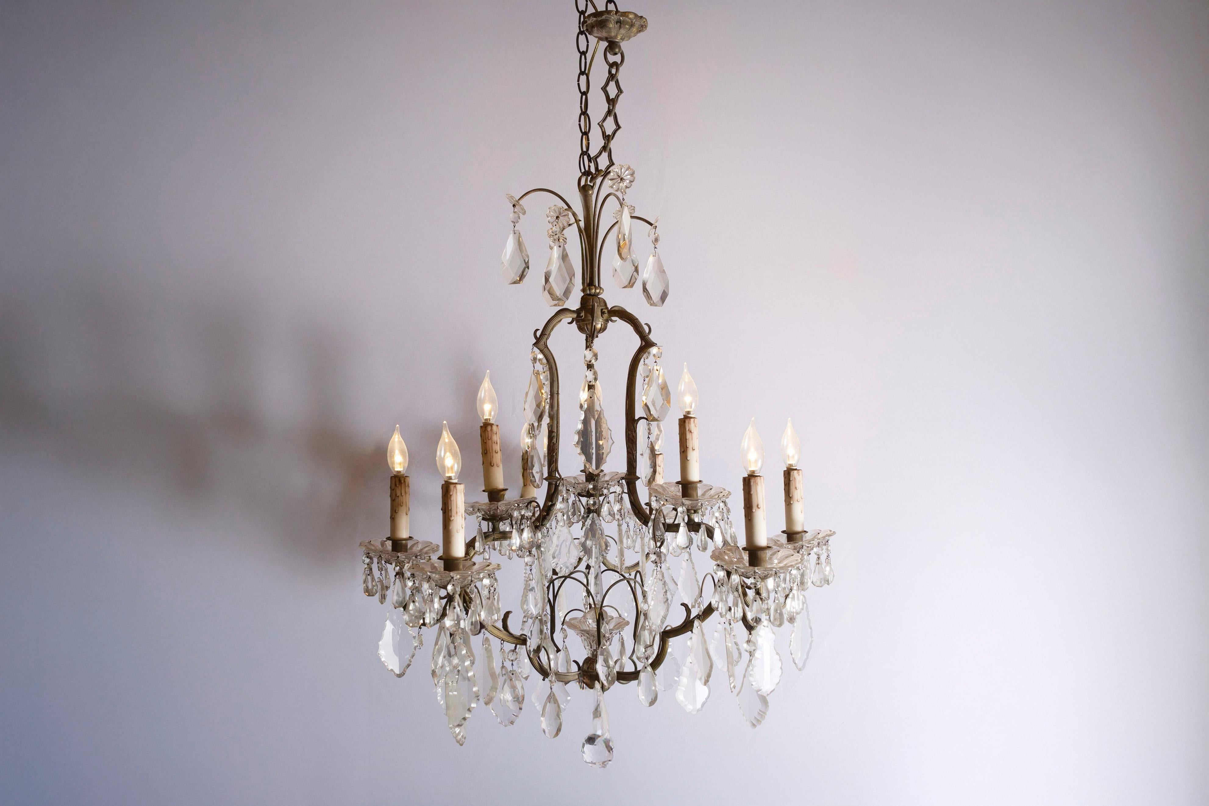 Lampadario a otto luci in cristallo francese del XIX secolo, con armatura in ferro. Nato in Francia durante il dinamico XIX secolo, questo lampadario è caratterizzato da una delicata armatura a spirale in ferro, ornata da cristalli sfaccettati,