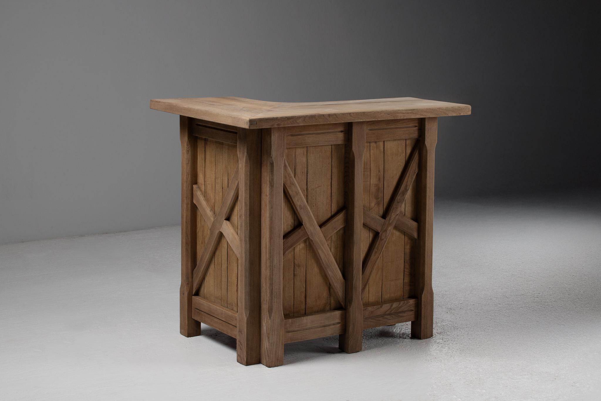 With a sharply faceted top and geometrically braced facade, this L-shaped bar in solid elm reads like an architectural fragment reimagined for intimate domestic rituals. The patinated wood top gently flares and folds like origami in timber, its