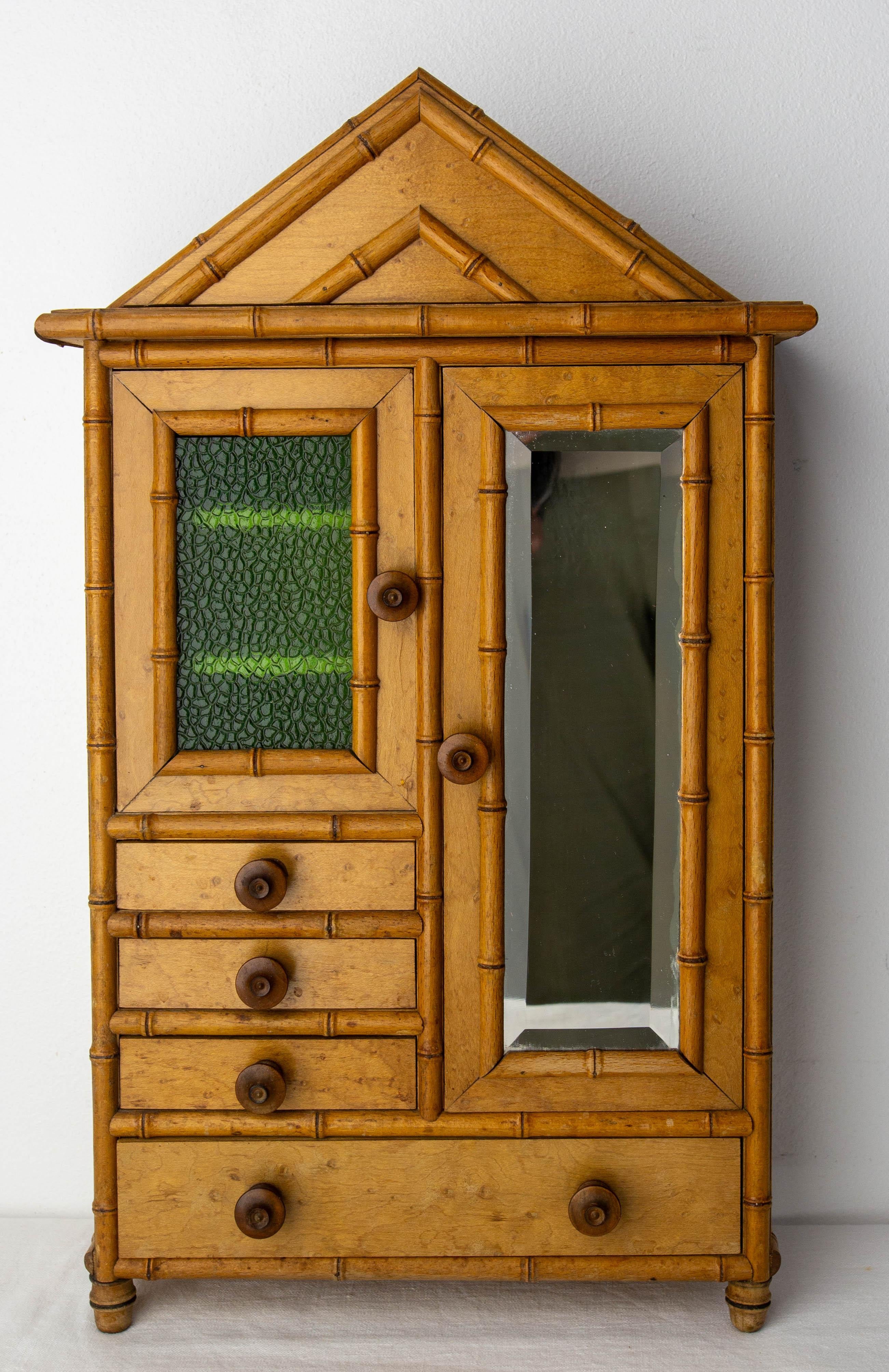 Little elm burl doll cabinet.
A great deal of care has gone into making this toy so that it closely resembles the real thing. The mirror on the door is bevelled, the shelving area is behind a green granited glass, and coat racks have been added to