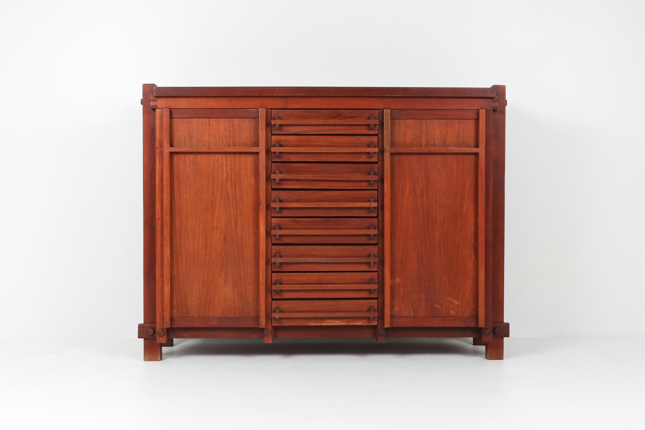 Mid-Century Modern cabinet in elm, France, 1960s.

Gorgeous storage piece made in extinct French elmwood.
The style mixes midcentury and brutalism, Pierre Chapo and Claudio Salocchi.
Symmetrical piece featuring 8 drawers in the middle of a door