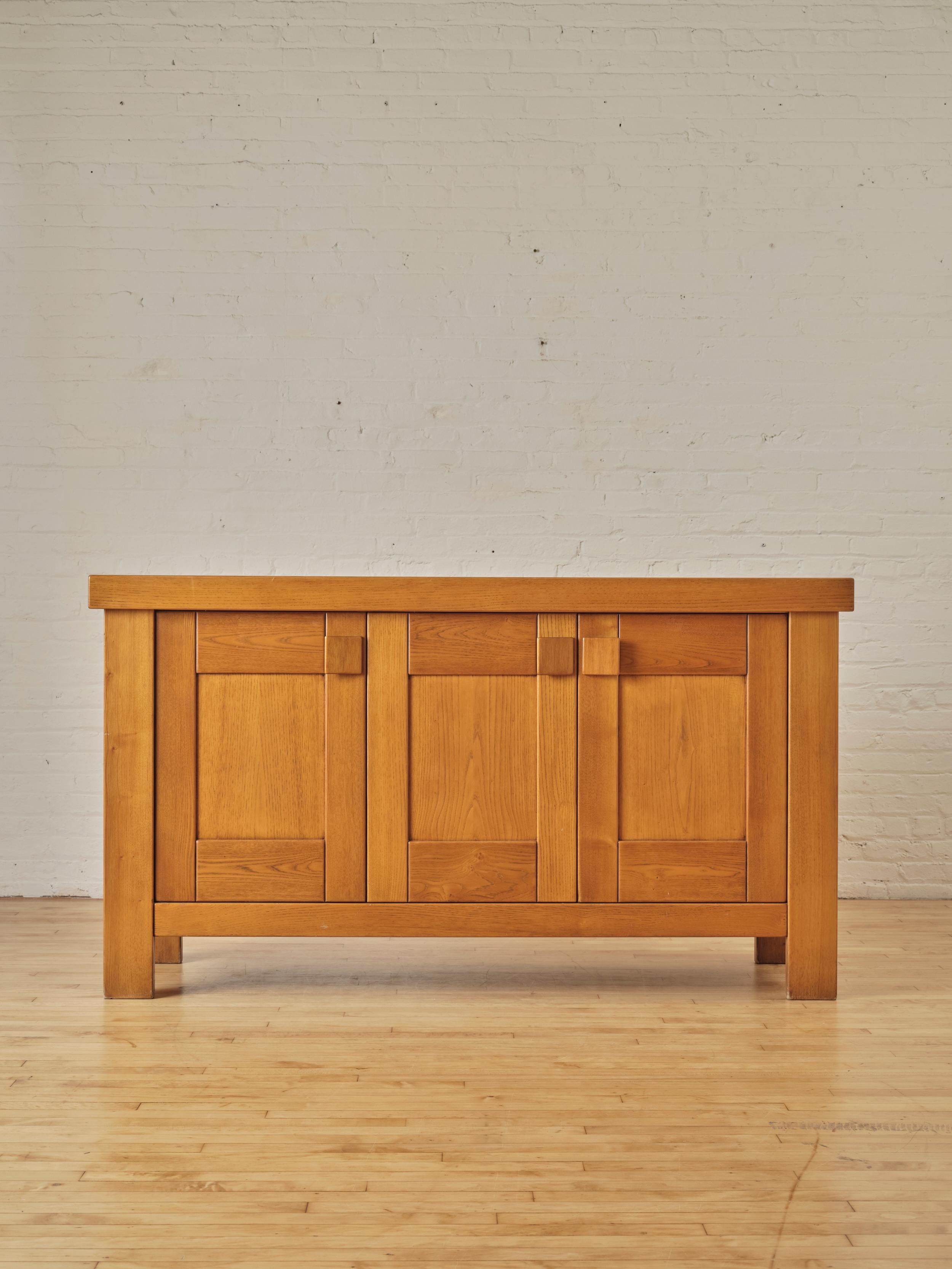 French Elm Sideboard by Maison Regain , featuring three doors with sculptural pulls that open up to reveal a single shelving unit.

