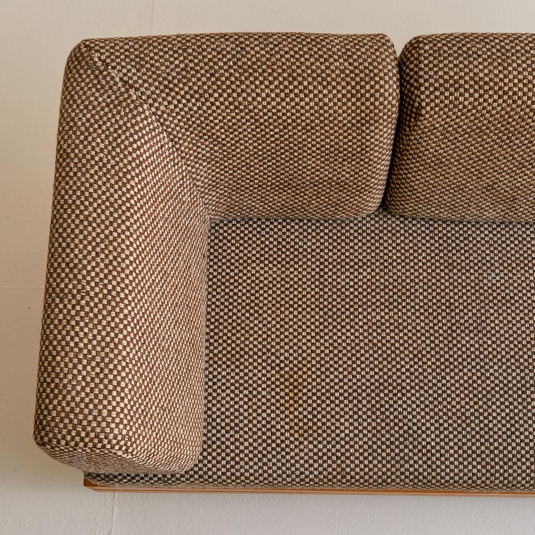 A rare sofa or daybed by Maison Regain, crafted in France during the 1970s. Constructed from solid elm, the frame highlights the studio’s signature construction—stacked wood banding, squared edges, and exposed joinery without visible hardware. The