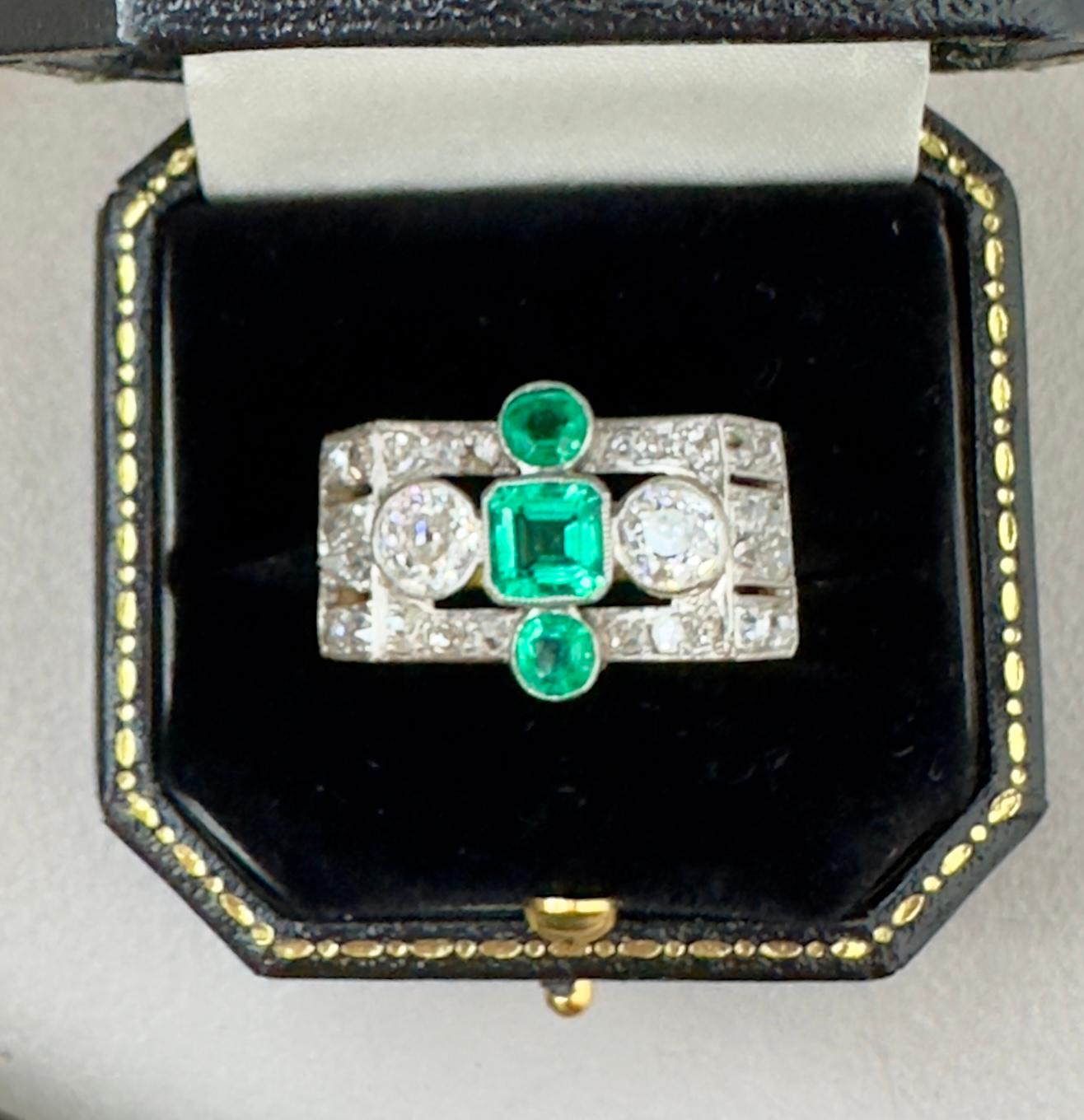 This ring, because of its shape and and war time era ,is called a Tank Ring. They are worn by both men and women and have a distinctive shape. This ring is set with exceptional deep green emeralds and various shapes of white diamonds.The two round