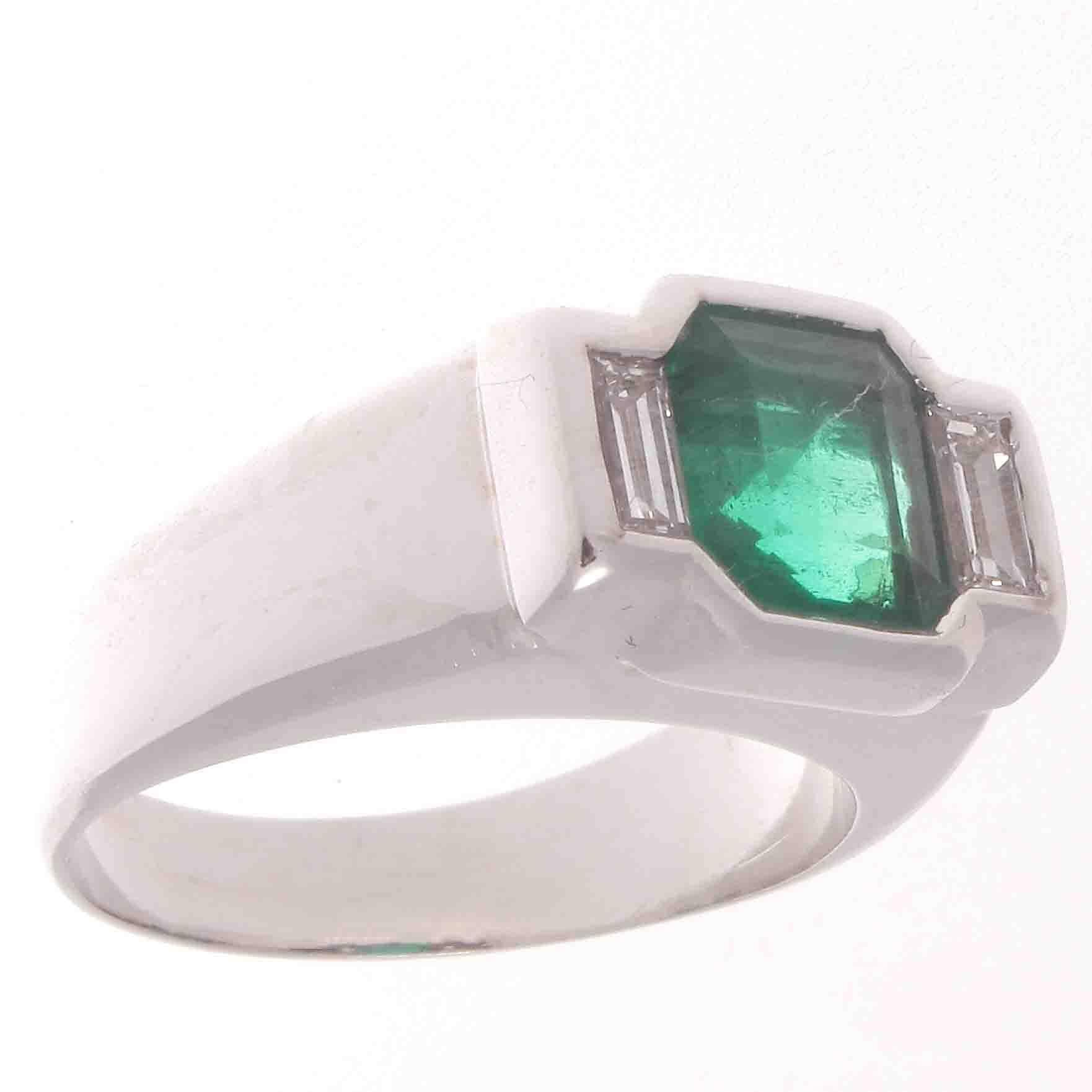 Smooth free flowing lines create this bold design. Featuring a gem quality forest green emerald that is approximately 1.50 carats expertly channel set with an accompanying colorless diamond on either side. Hand crafted in platinum.

Ring size 5-1/2