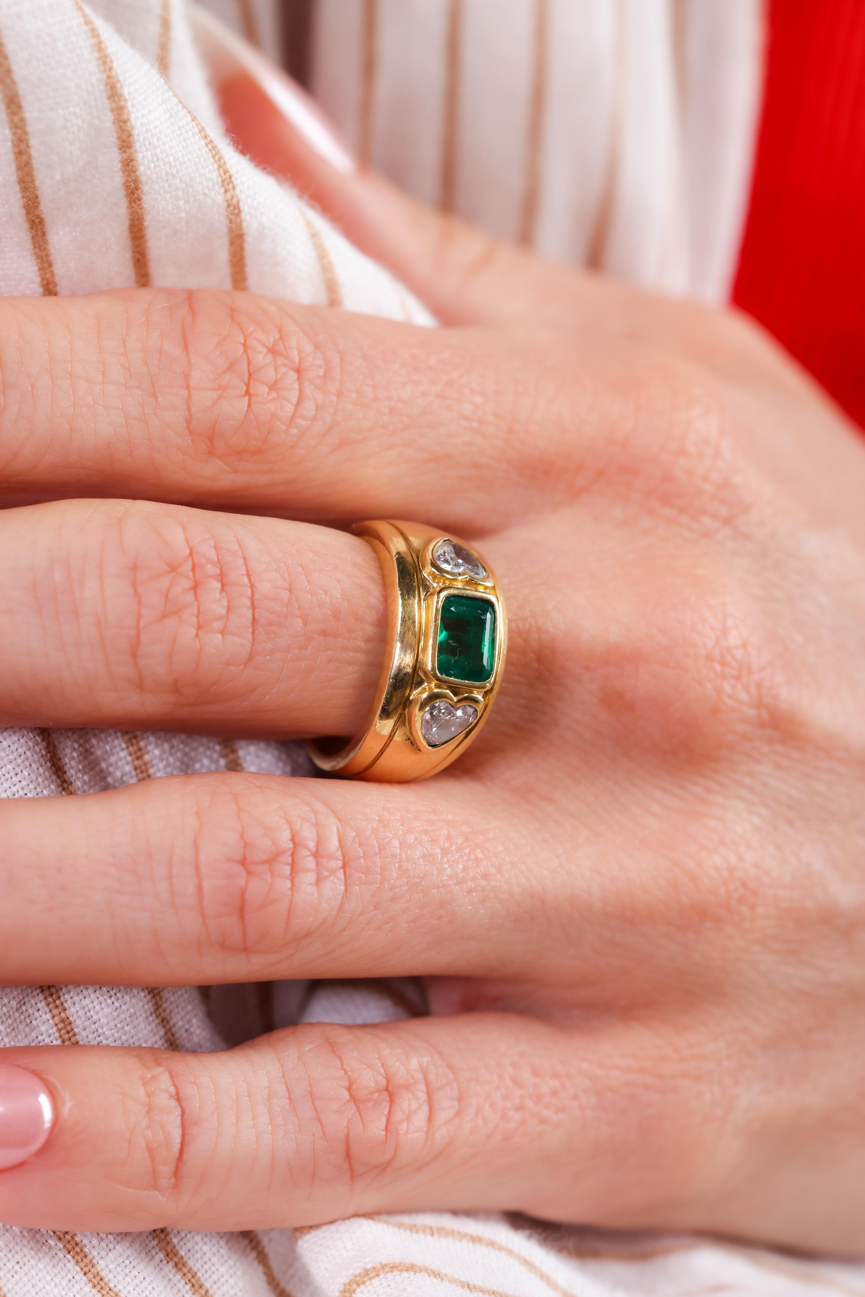 Mittelstein: Smaragd
Schliff: Smaragd
Gewicht: ca. 1 Karat 
Akzentstein: 2 Diamanten 
Schliff: Herzform 
Gewicht: ca. 1 Karat 
Farbe: G-H
Klarheit: VS2-SI1
Metall: 18k Gelbgold 
Circa: 1980er Jahre
Punzierungen: Französisch assay 
Größe: 6-1/4 und