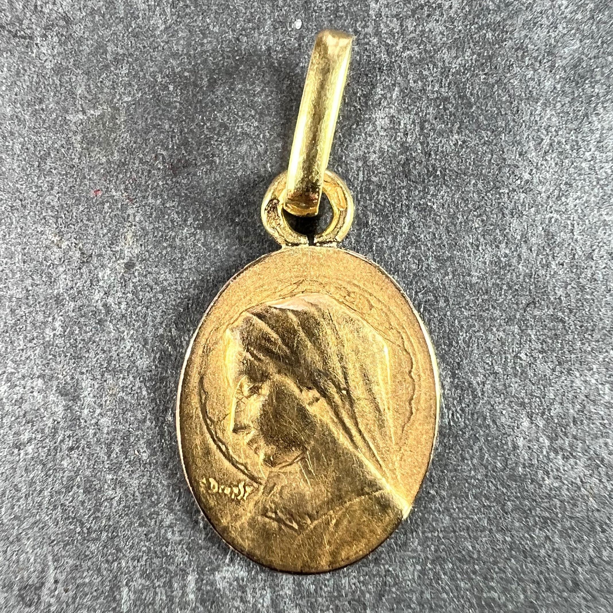 An 18 karat (18K) yellow gold oval charm pendant designed as a medal depicting the Virgin Mary. Signed E.Dropsy. Stamped with the eagle’s head for French manufacture and 18 karat gold with an unknown maker''s mark.

Dimensions: 1.7 x 1.1 x 0.1 cm
