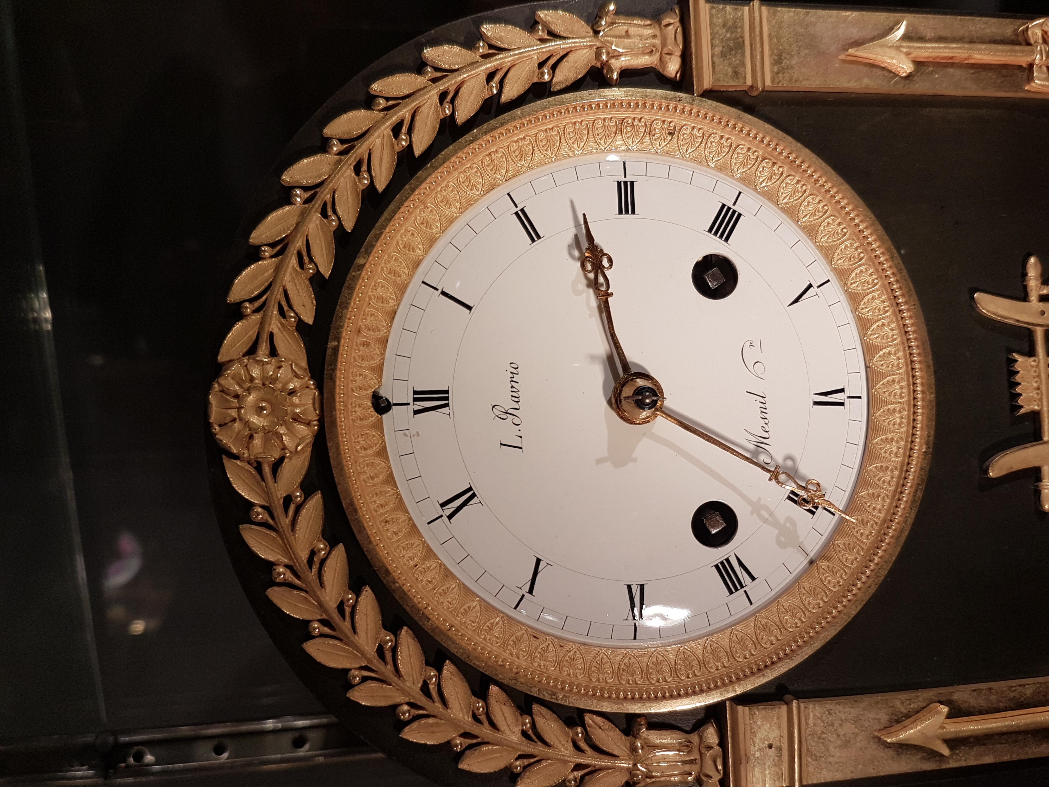 Französische Empire-Uhr von hervorragender Qualität in getragener Form aus rougefarbenem Marmor, original feuervergoldetem Ormolu und patinierter Bronze. Das Zifferblatt der Uhr ist unter 12 Uhr mit 