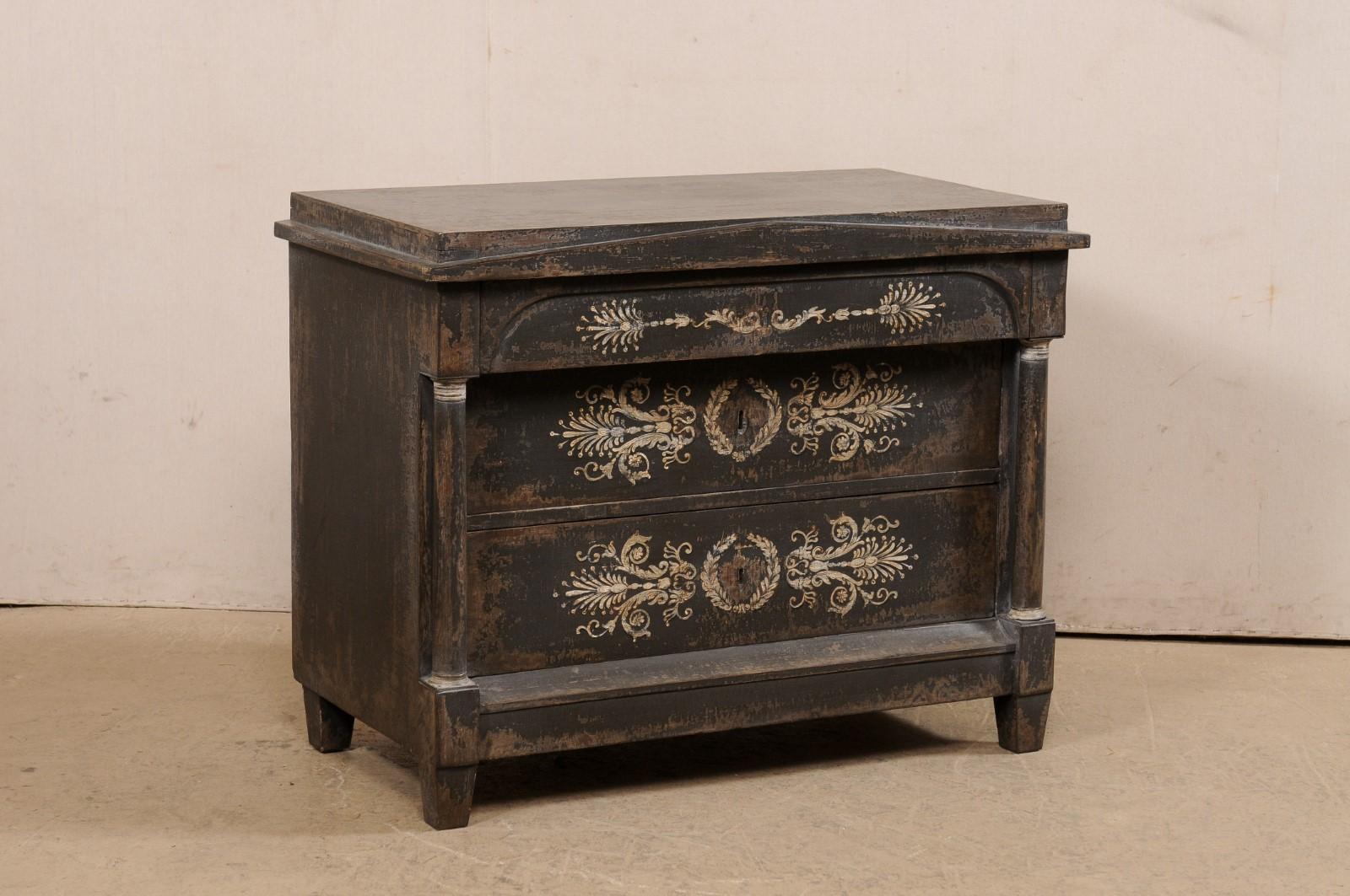 A French Empire commode, with an artisan hand-painted finish, from the 19th century. This antique chest from France has a rectangular-shaped top, which is slightly recessed upon a lower perimeter lip, and front has a pediment-style triangular