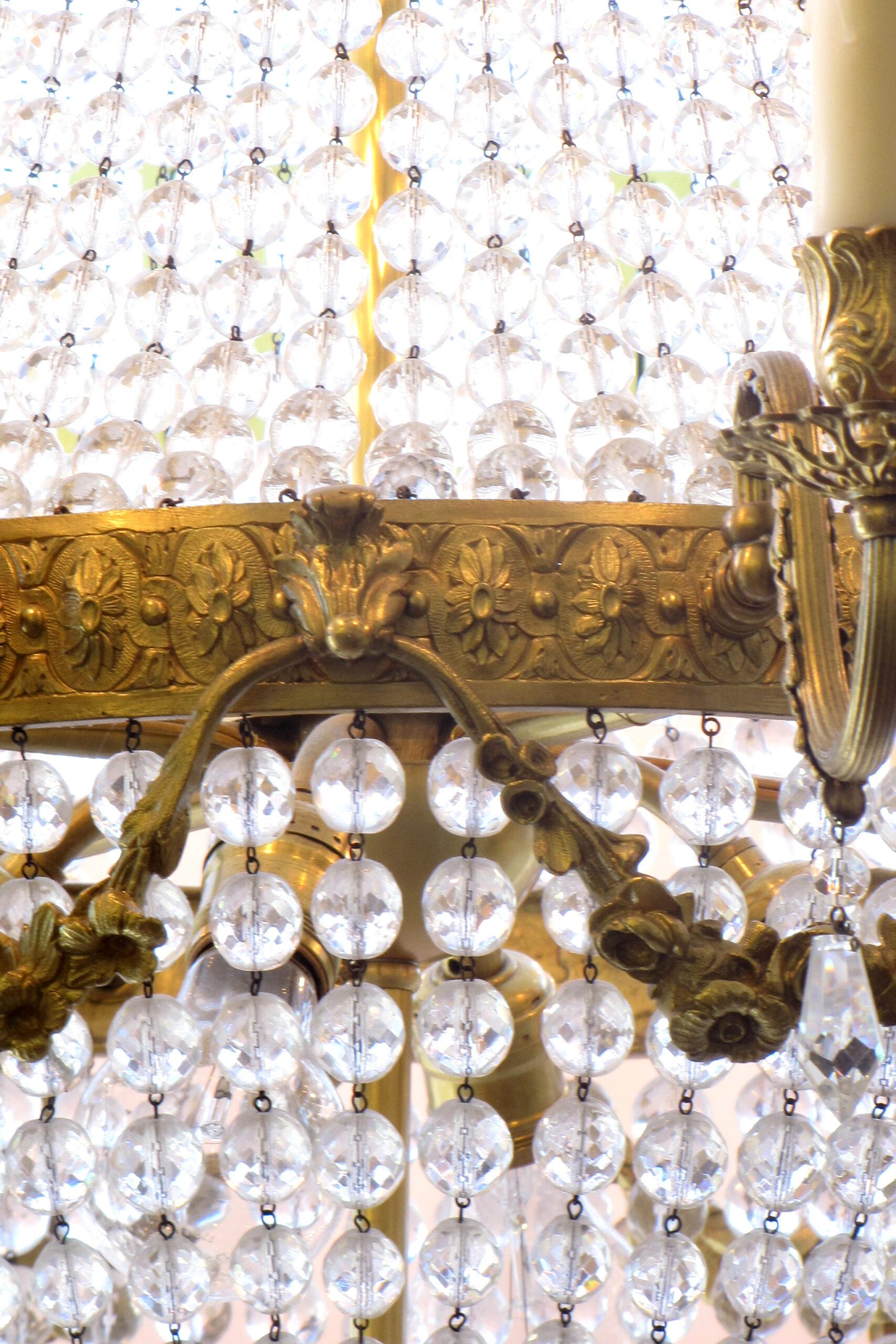 Vergoldete Bronze und Kristallkronleuchter mit schönem Guss. Vollständig restauriert, verkabelt und einbaufertig. Französischer Empire-Stil, Ein Korb mit Kristallen, umgeben von vergoldeten Bronzearmen. Acht Lichter im Außenbereich und vier im