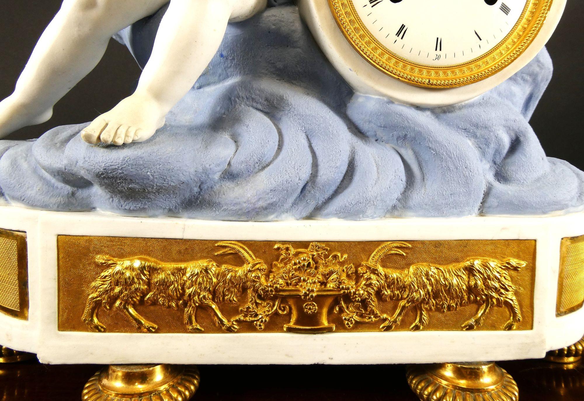 French Empire Ormolu and Bisque Porcelain Mantel Clock

French Empire ormolu mounted Bisque porcelain mantel clock surmounted by a winged cherub, Gilded classical frieze below the dial featuring two goats standing on turned and chased feet with