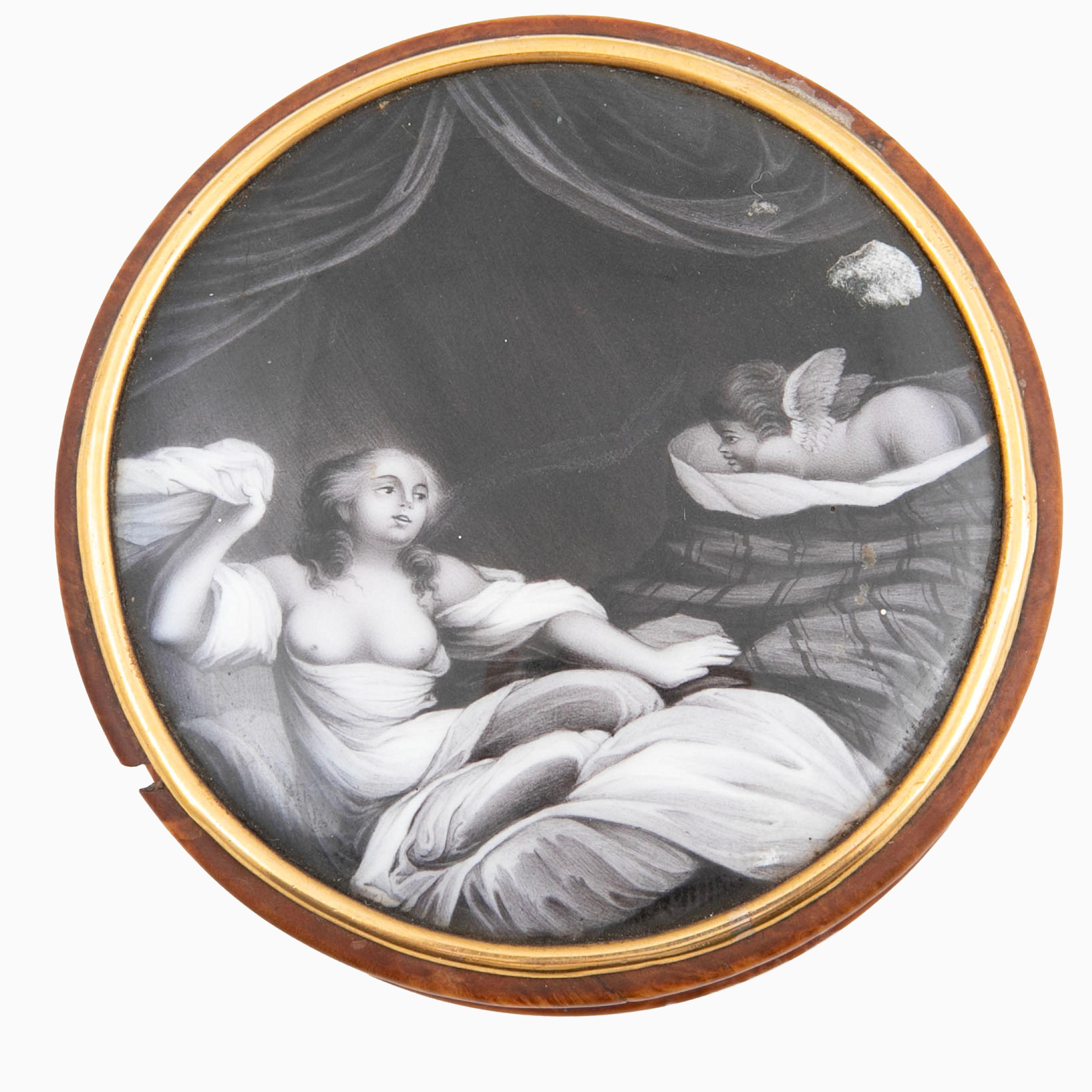 Une tabatière Empire française, délicieusement travaillée en buis.
Le couvercle est orné d'une plaque érotique en émail, élégamment encadrée par une bande de bronze doré, tandis que le dessous présente un anneau de bronze doré assorti.
L'intérieur