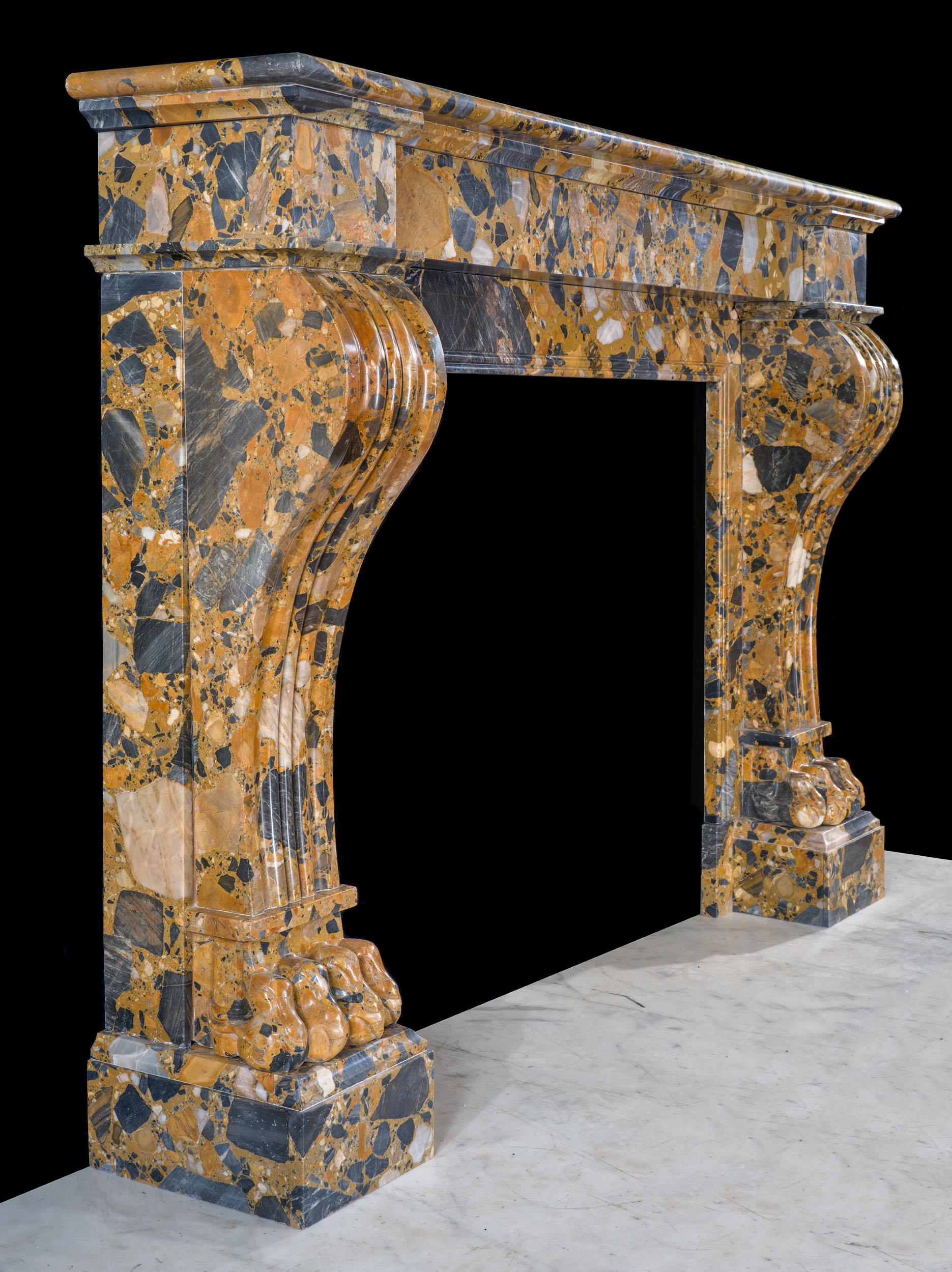 A striking French Empire fireplace in an unusually bold Brèche de Médous marble. The plain shelf and endblocks are supported by dramatic, scrolling console jambs over lion paw feet.

French, 19th century.