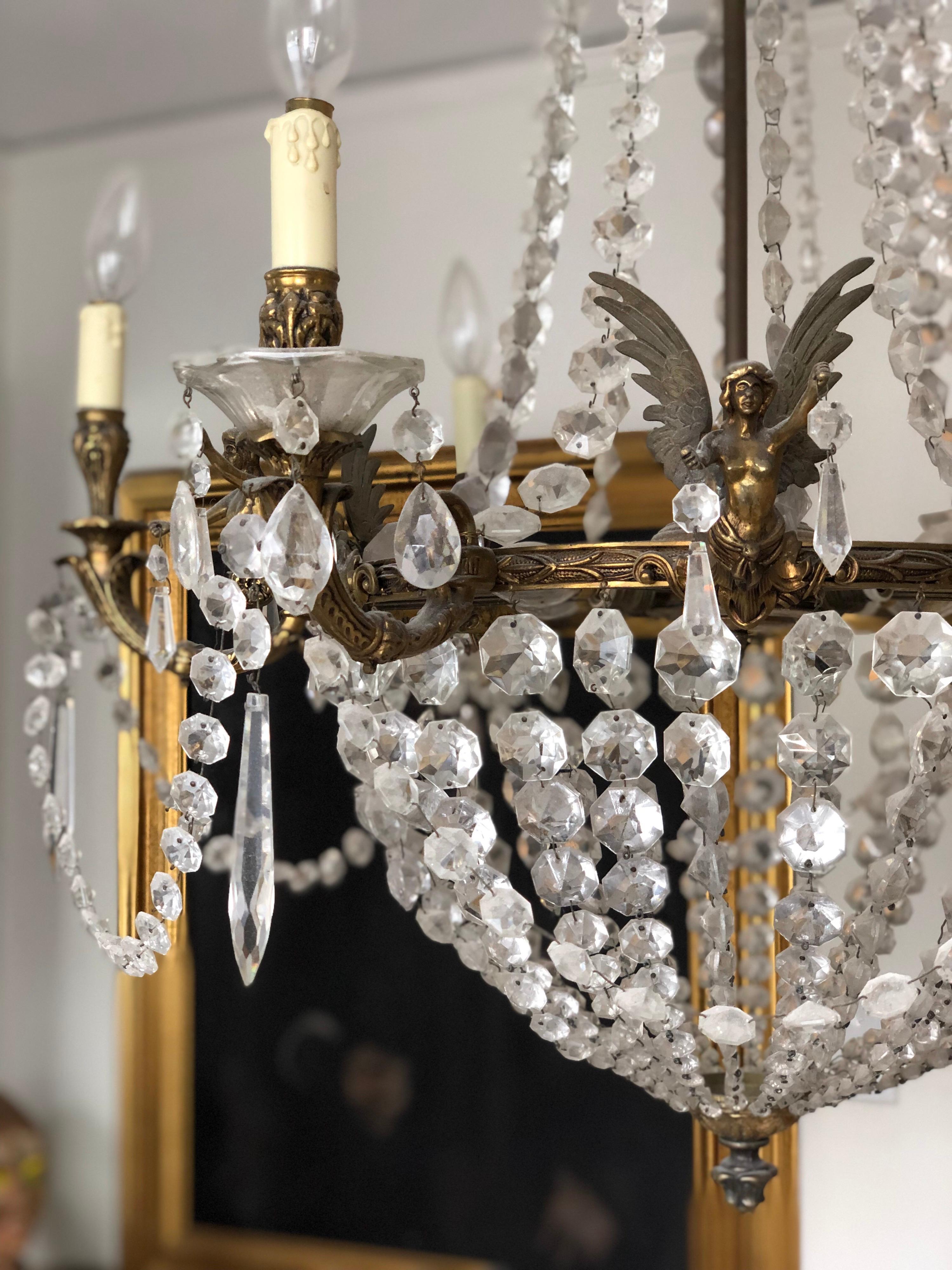 Antique French Empire style Sac a pearl/tear drop chandelier. Six exterior candelabra lights with 6 interior.
Features six angels/cherubs holding crystals. 

Approx 40 inch drop...currently 43 as it's currently hanging.