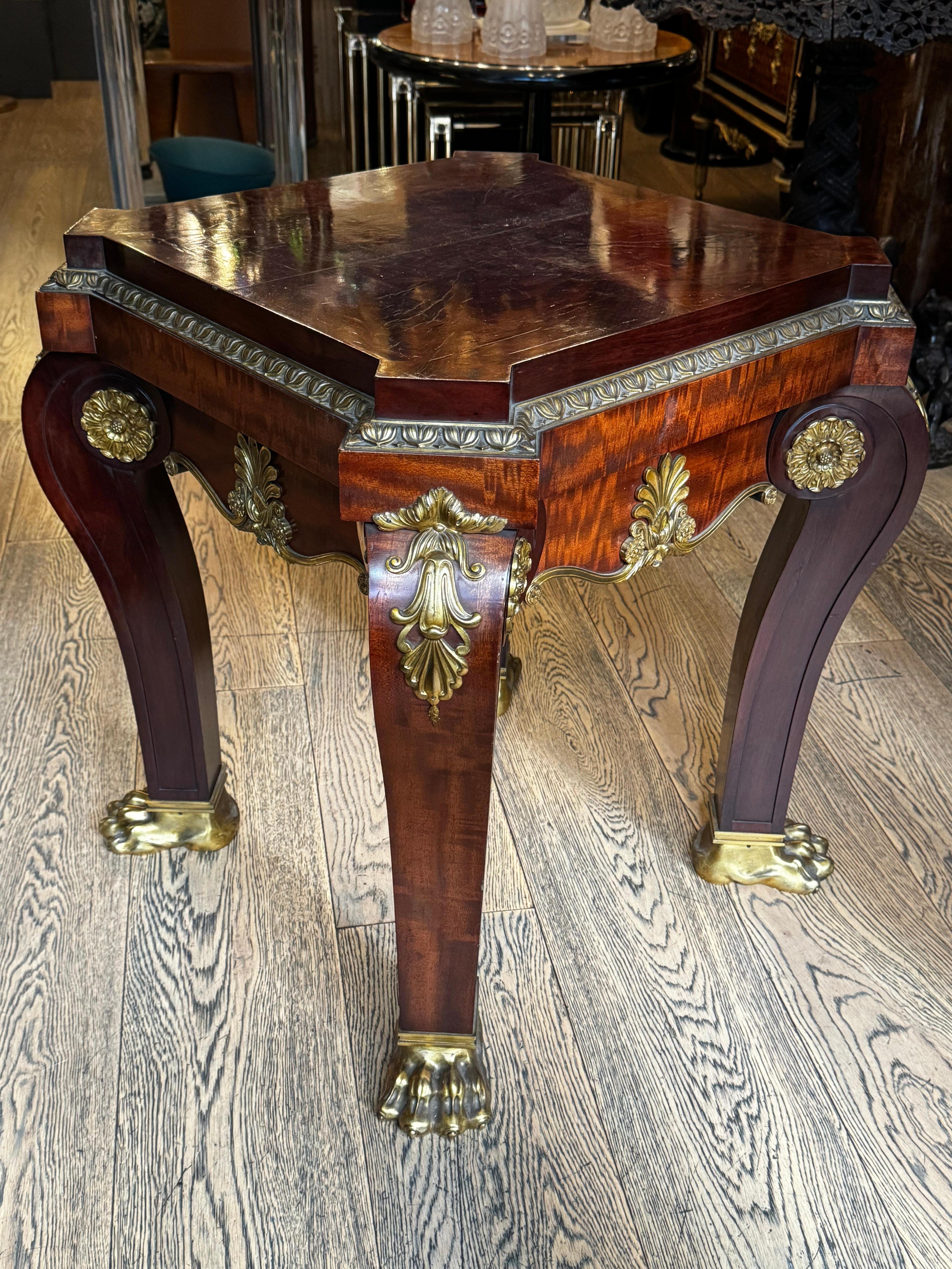 This exquisite French Empire table, masterfully crafted from the finest mahogany and adorned with ornate bronze detailing, is a quintessential representation of the opulence and precision that defined early 19th-century craftsmanship. The table's