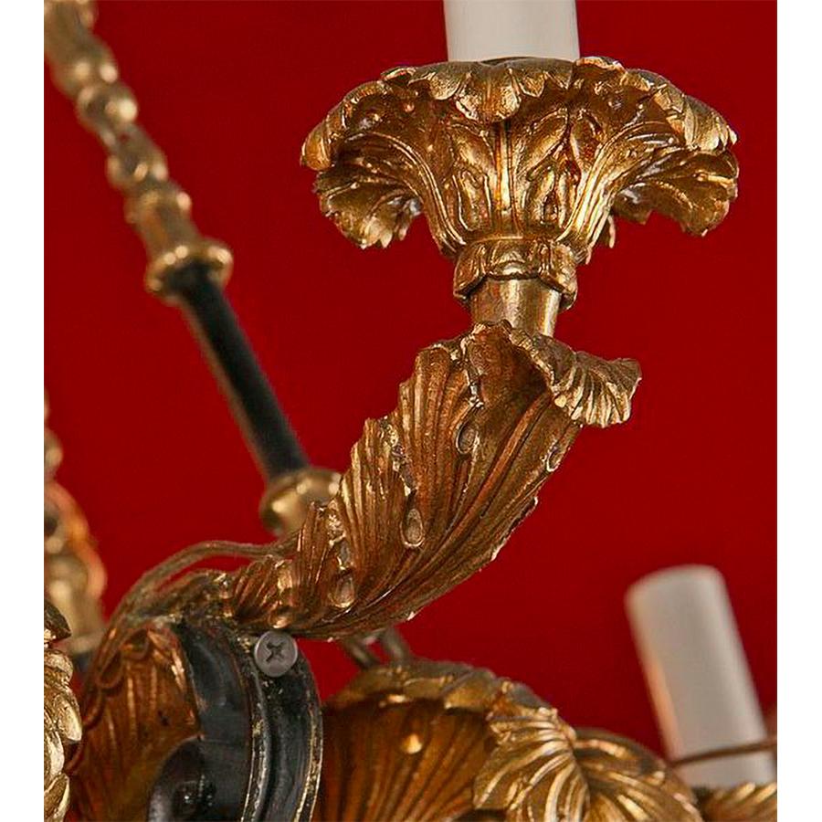 A French Empire patinated and gilt bronze six-light chandelier with acanthus leaf decoration and acorn finials.