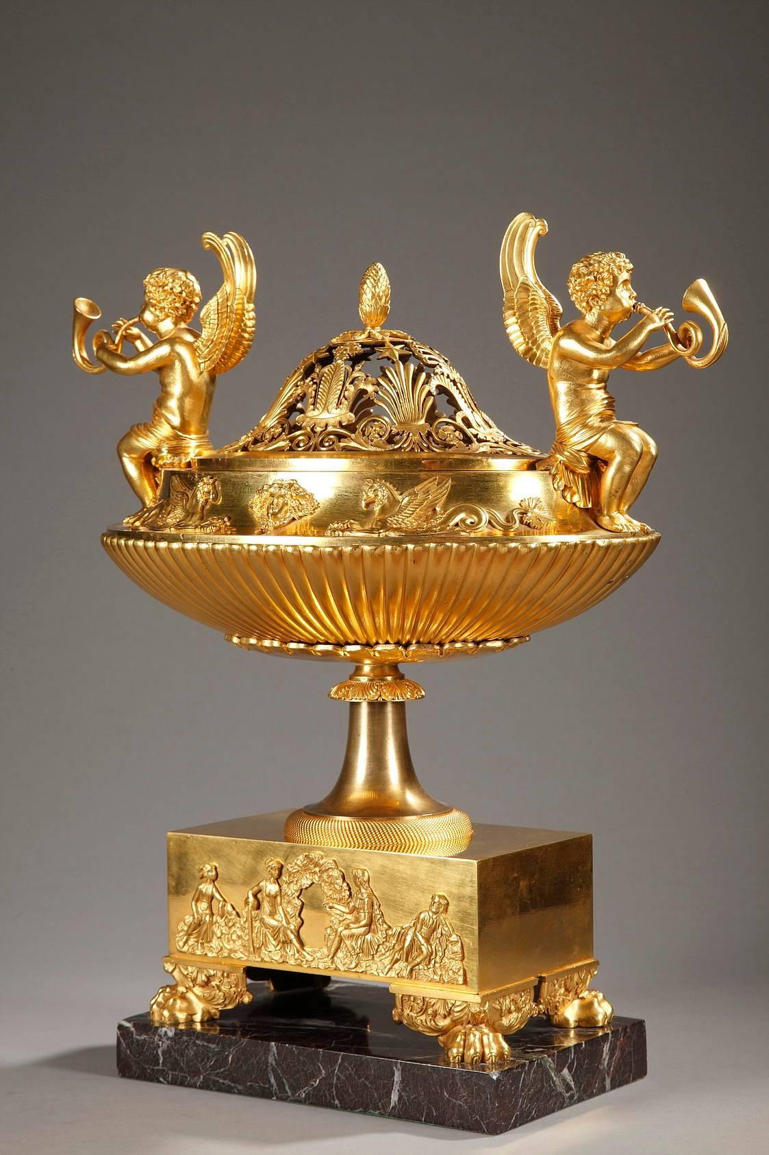 Ormolu perfume burner or potpourri holder that serves as a striking table centerpiece. The openwork lid is adorned with palmettes, foliage, small flowers, and stars. Two winged Hermes playing trumpets sit on the perfume dish and form the handles.