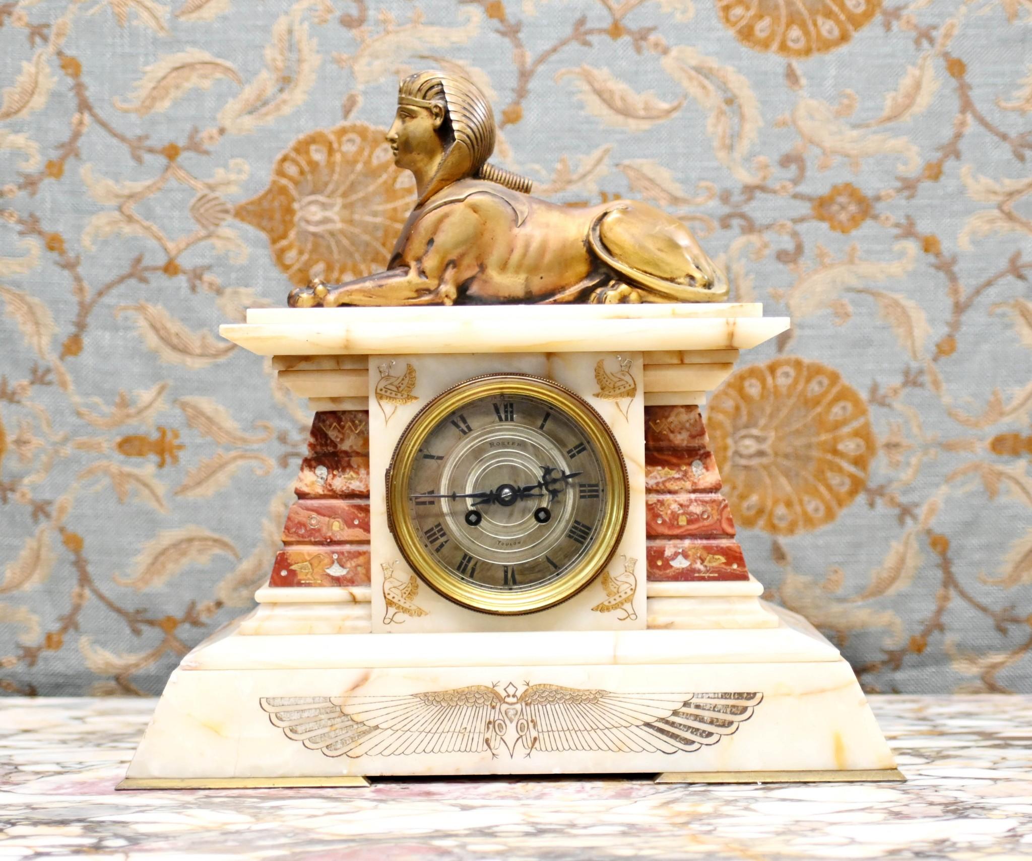 Gorgeous French Empire mantel clock in marble and gilt
Piece is surmounted - very high Empire - by the gilded sphinx
Classic Egyptian style with specicmen marble supports and Egyptian motifs
Clock face is inscribed with 'Rozier' and 'Toulon'
Working