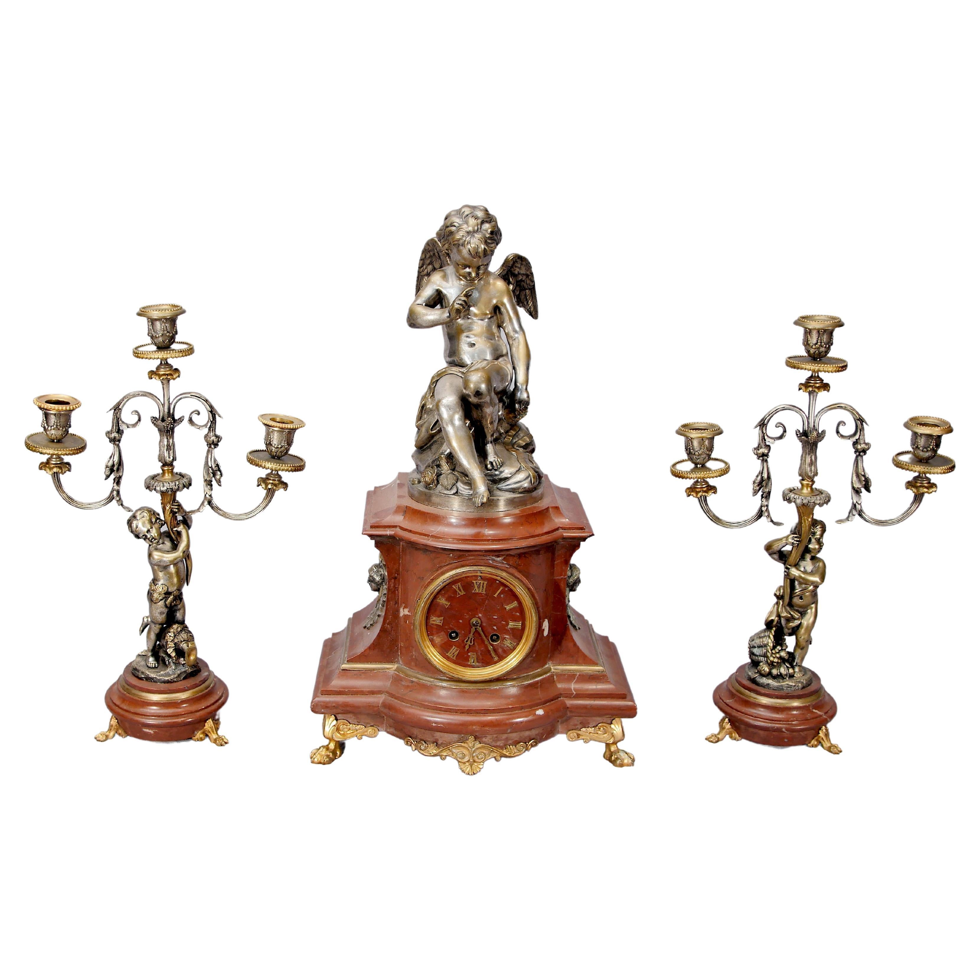 Ensemble d'horloges Empire française avec garnitures et candélabres dorés en forme de chérubin en vente