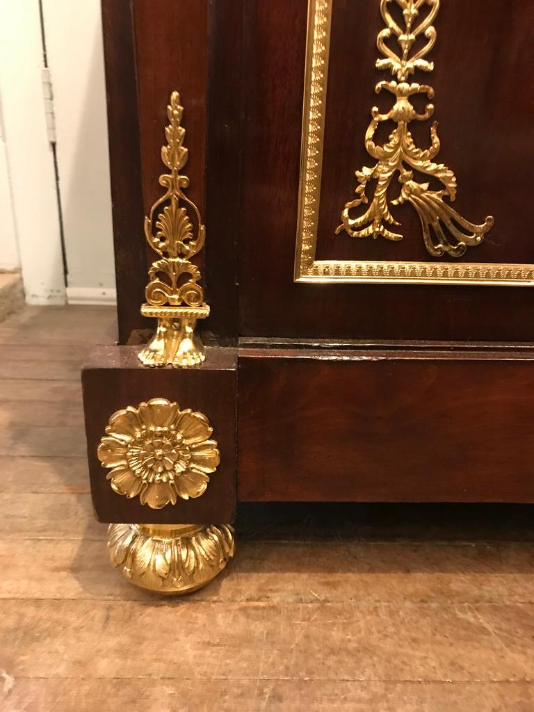 A fantastic quality 19th Century Empire mahogany and ormolu commode with marble top. This commode has three functioning, deep drawers with lovely gilded plaques.