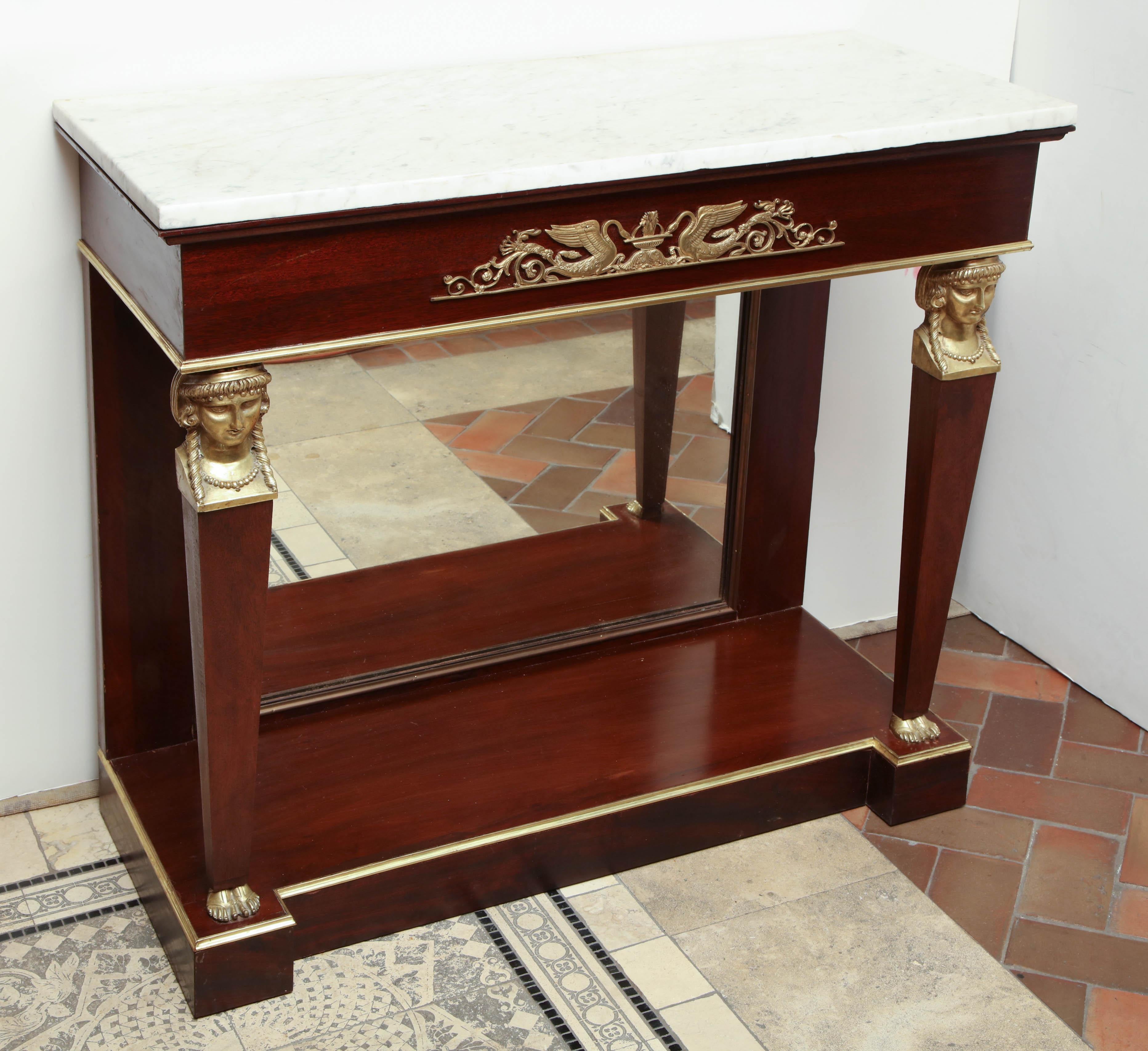 French Empire marble-top mahogany console table with bronze mounts, capital, a mirror back on a shelf stretcher n base.