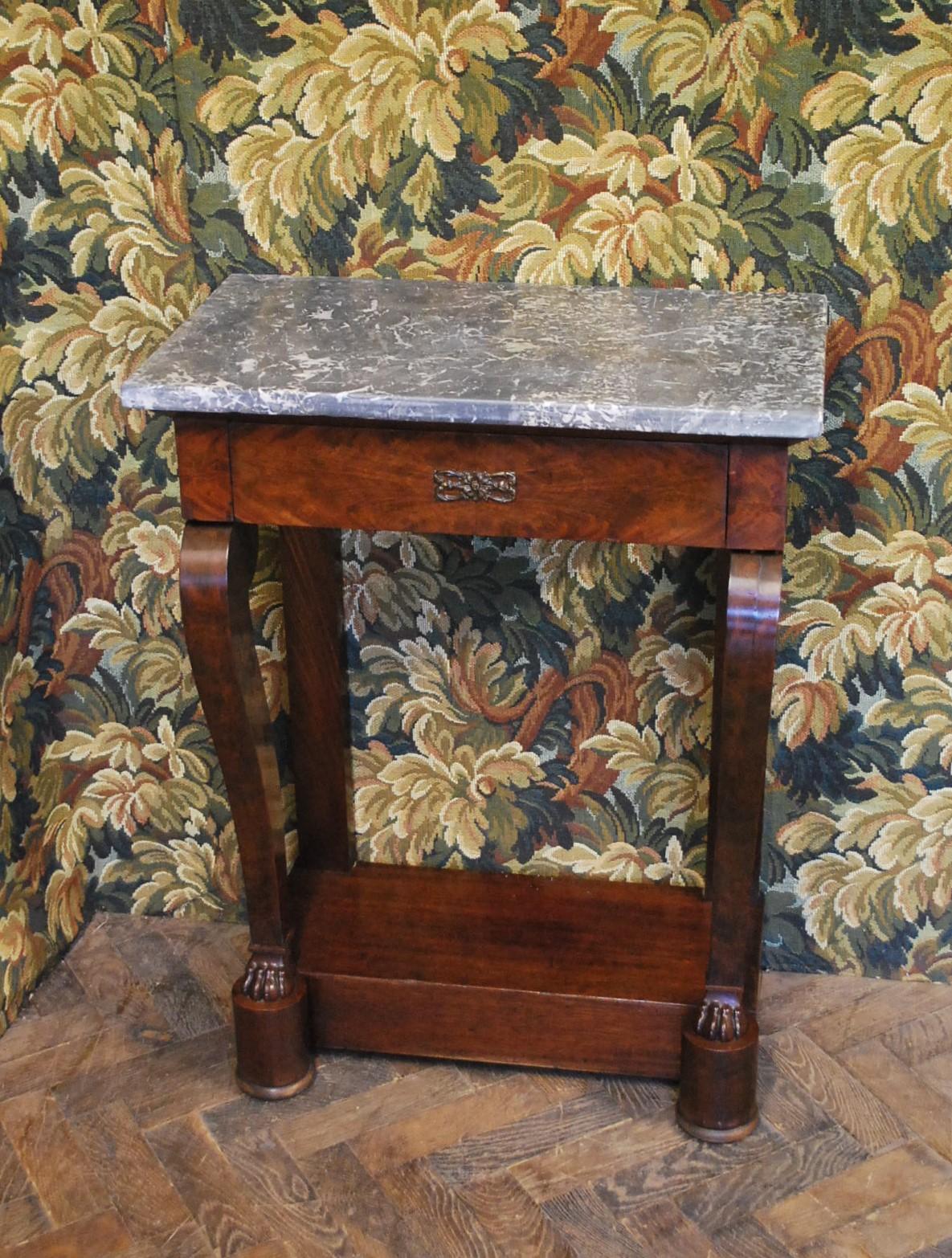 Hutton-Clarke Antiques takes great pride in presenting a remarkable piece of history: a French Empire console table, crafted around 1820. This exquisite piece showcases the timeless elegance of flamed mahogany, complemented by an original figured