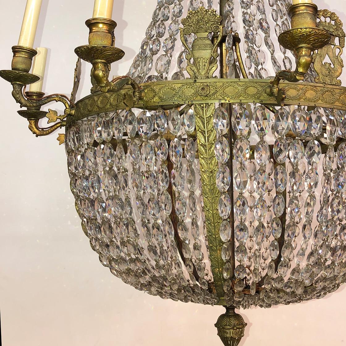 A French Empire crystal and bronze 10 light chandelier with elaborate palmettes, lyre mounts, and swan form arms.