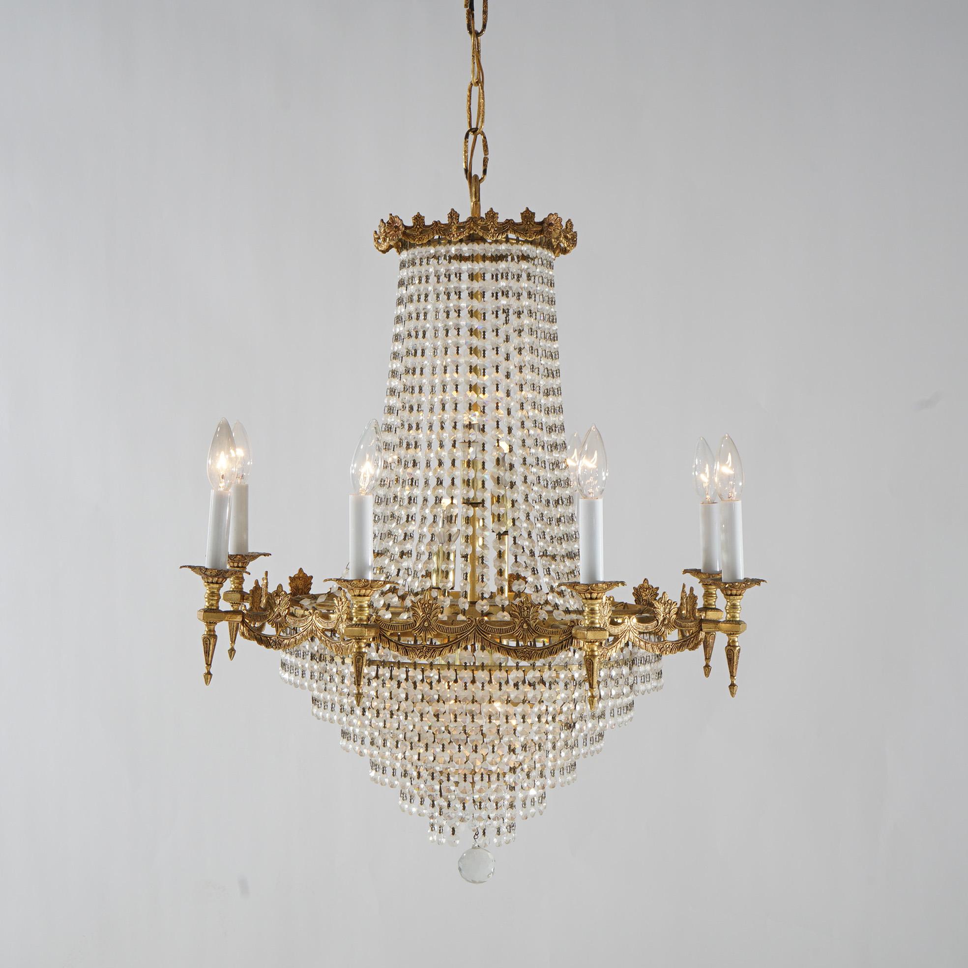 A French Empire style wedding cake chandelier offers gilt bronze frame with twelve arms terminating in candle lights and strung crystals throughout, 20th century

Measures - 39